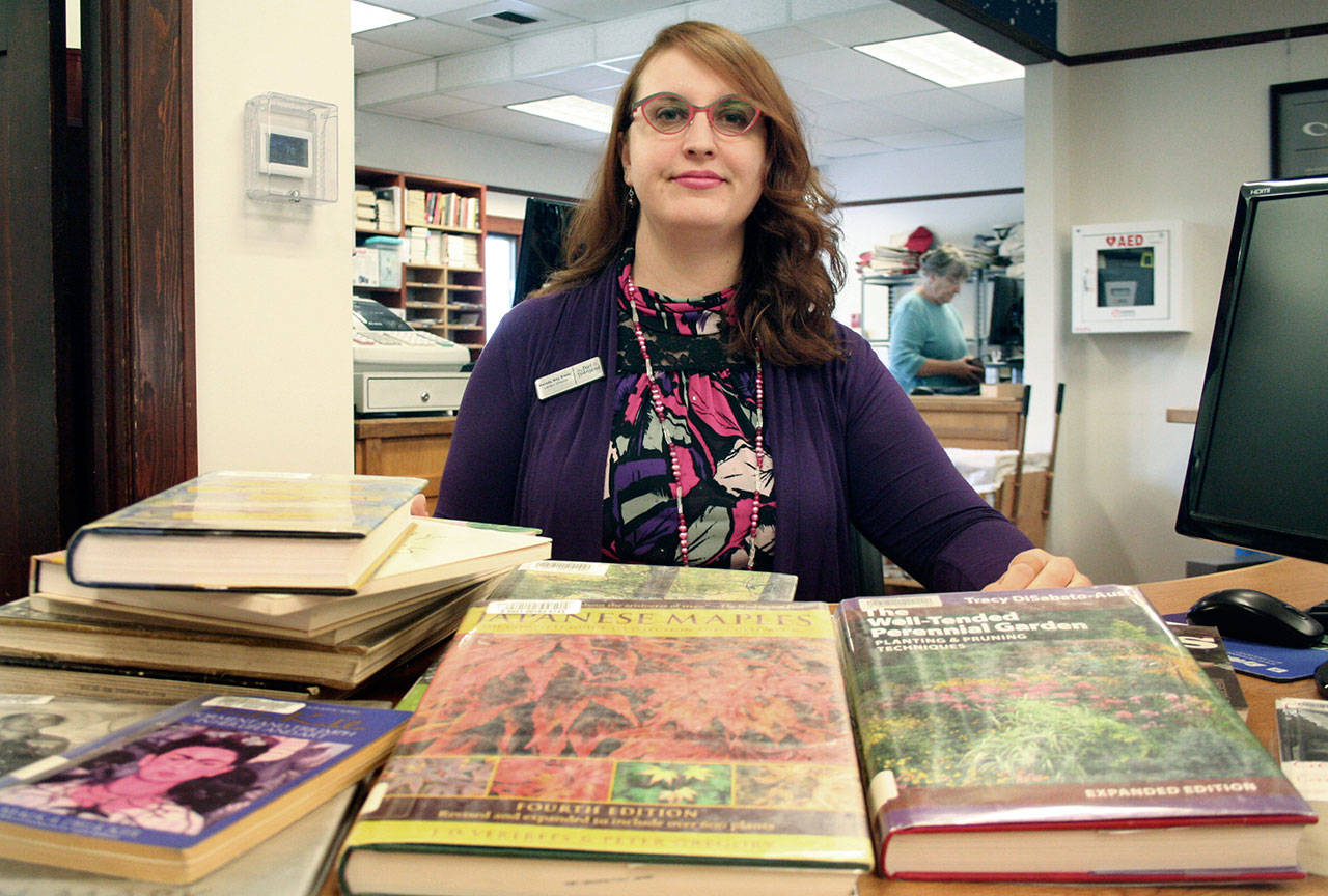 Melody Sky Eisler, the director of the Port Townsend Public Library, displays gardening books and others that focus on women artists, two subjects that will soon see an increase in supply following a donation accepted during Monday night’s City Council meeting. (Brian McLean/Peninsula Daily News)