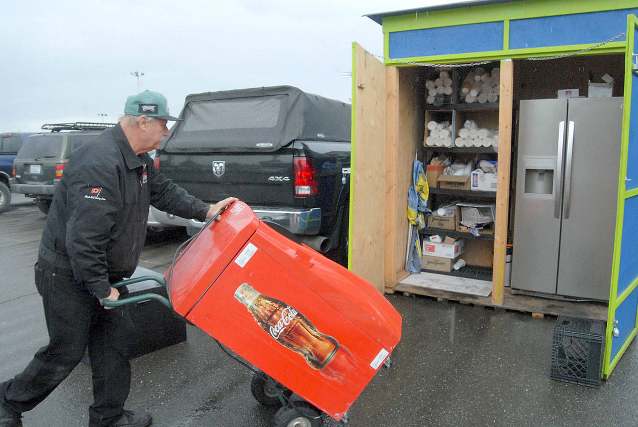 Stan Grall, co-owner of Celestial Espresso, wheels a soft drink cooler to a storage shed Tuesday after being told the business had to be cleared from its Railroad Avenue location to make way for a hotel being built by the Lower Elwha Klallam Tribe. (Keith Thorpe/Peninsula Daily News)