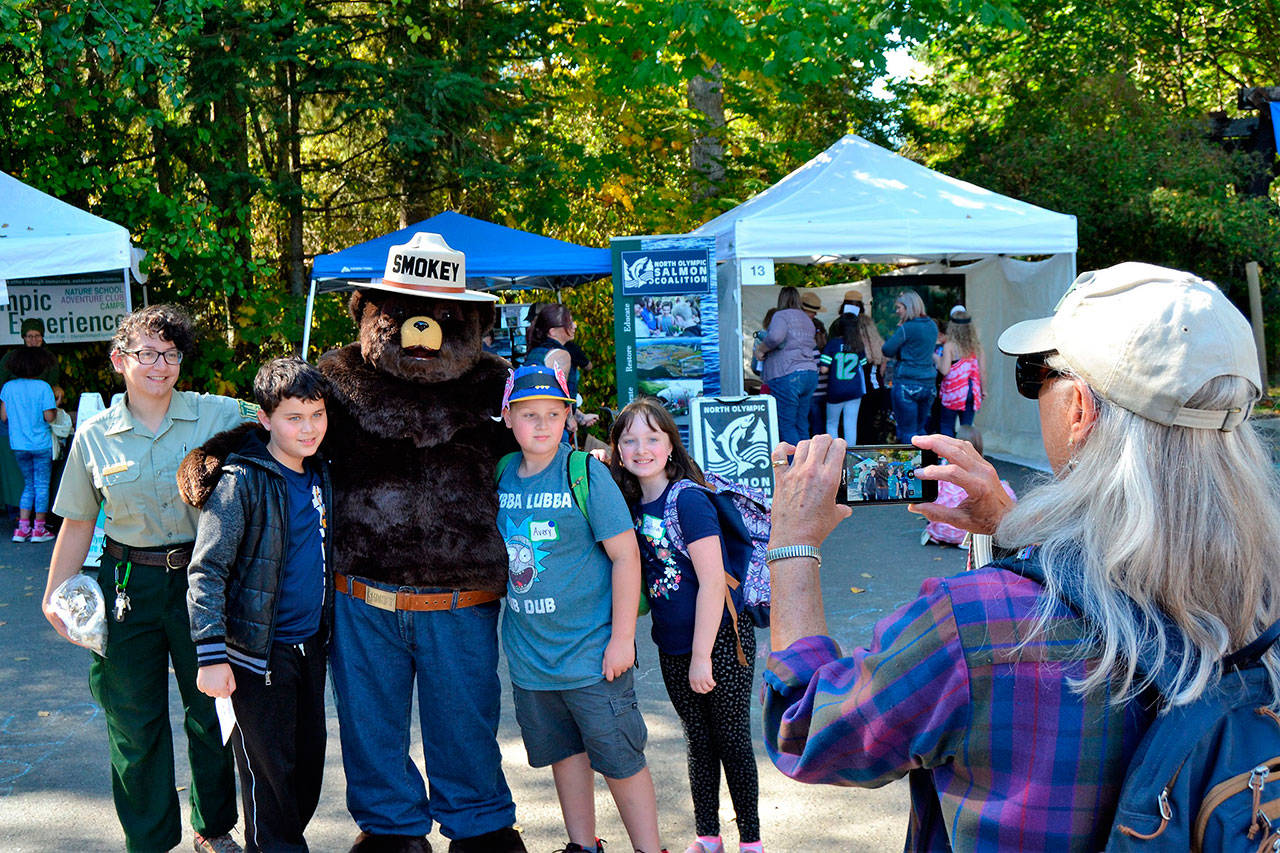 Smokey Bear lines up for a photo for grandparent volunteer Mikie Morris at last year’s Dungeness River Festival. Pictured with Smokey are, from left, Alex Crnic, field ranger for the U.S. Forest Service, Lincoln Terwilliger, Avery Morris and Sophia Rhynes. (Matthew Nash/Olympic Peninsula News Group)