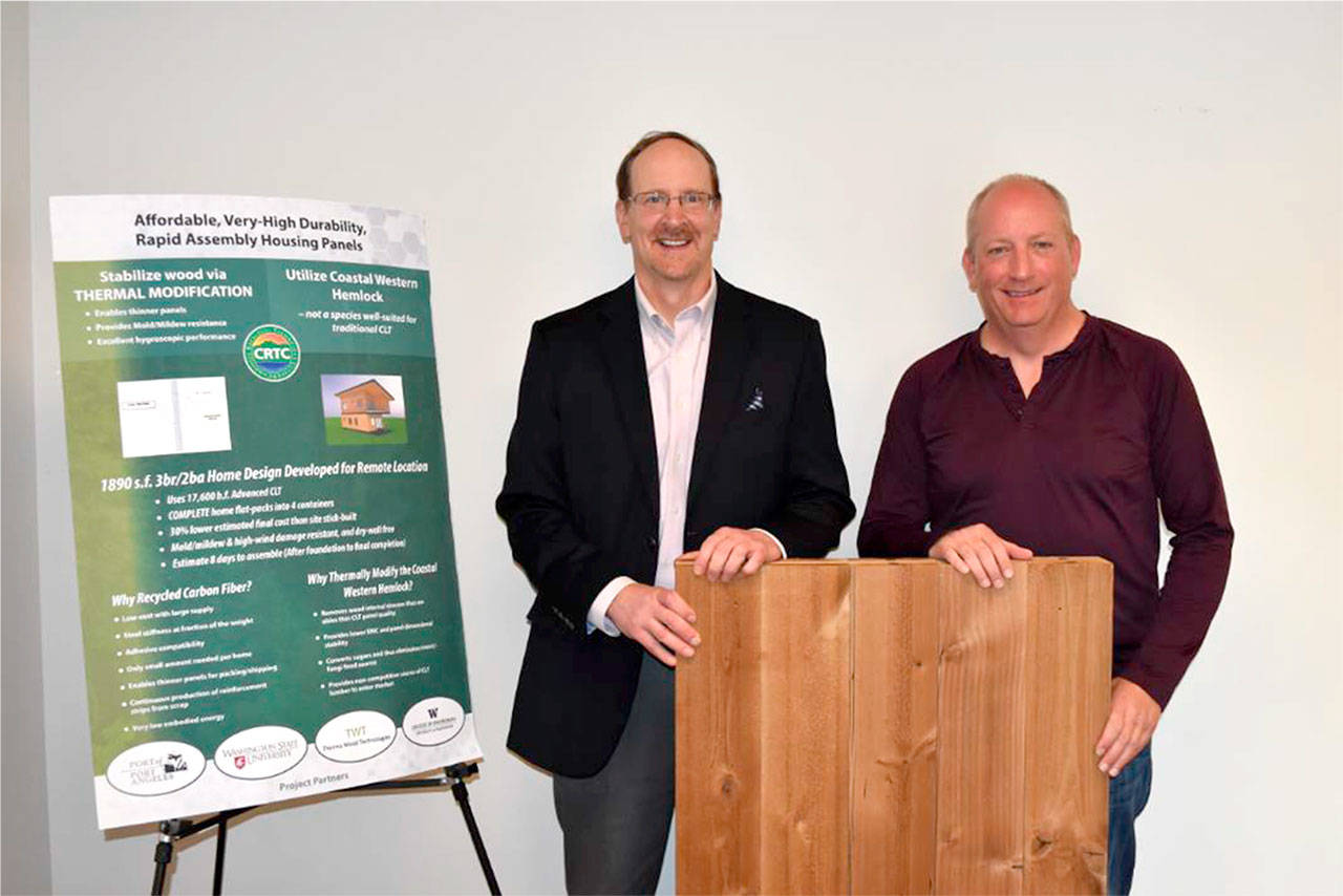 Dave Walter, left, CEO of the CRTC and Matthew Rainwater, founder and president of Pennies For Quarters, stand in front of an advanced cross-laminated timber panel. (CRTC)