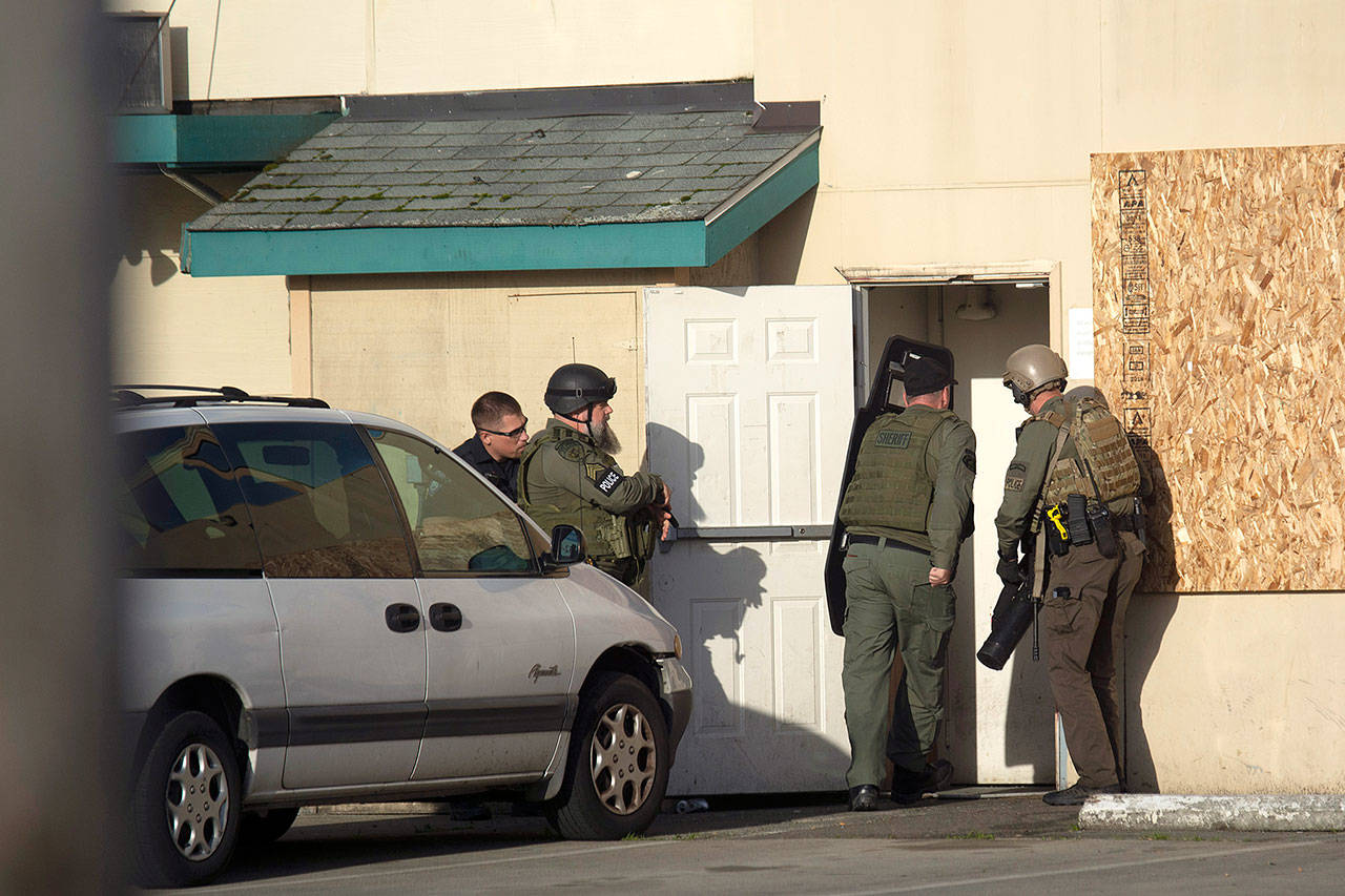 Olympic Peninsula Narcotics Team members enter the Tempest permanent-supportive housing appartments to serve a search warrant Wednesday. (Jesse Major/Peninsula Daily News)