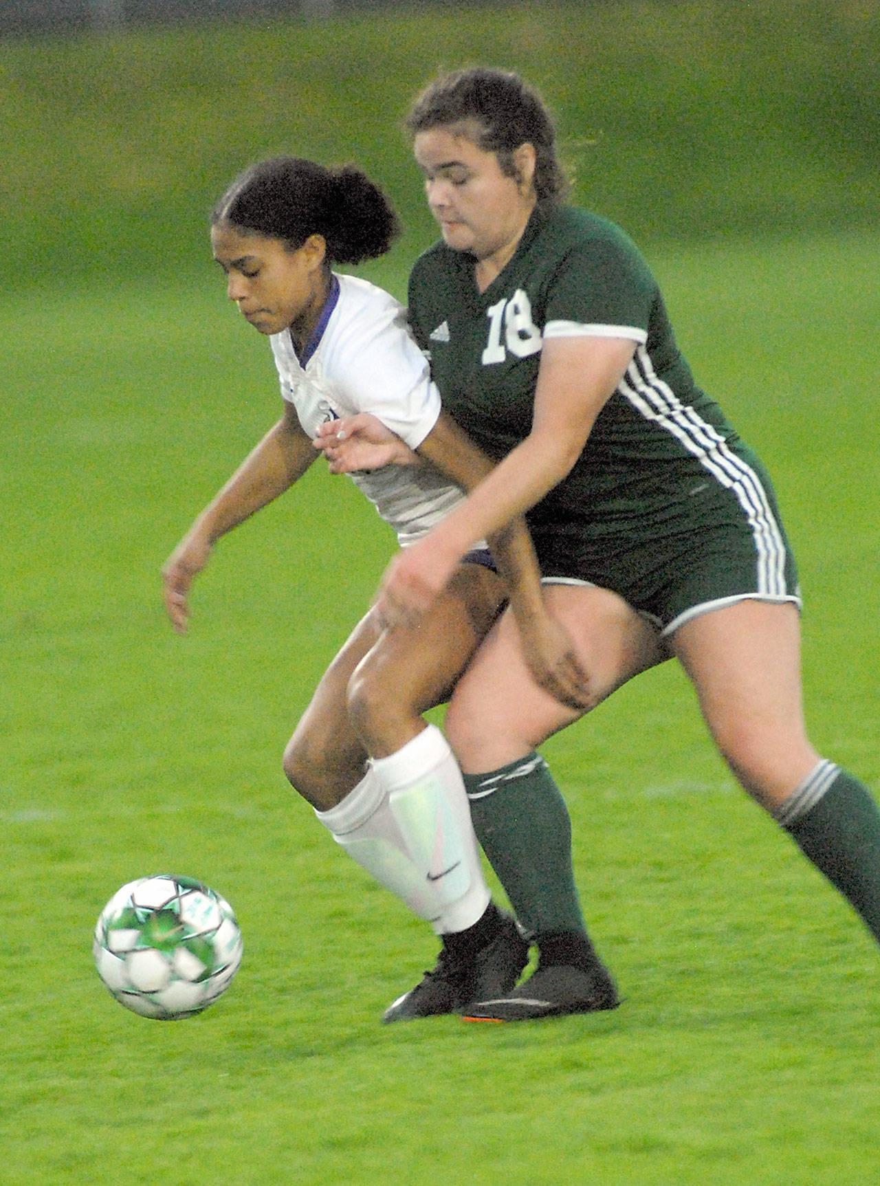 Keith Thorpe/Peninsula Daily News North Kitsaps Kamora McMillian, left, and Port Angeles Kiana Watson-Charles battle for ball control on Thursday night at Port Angeles Civic Field.