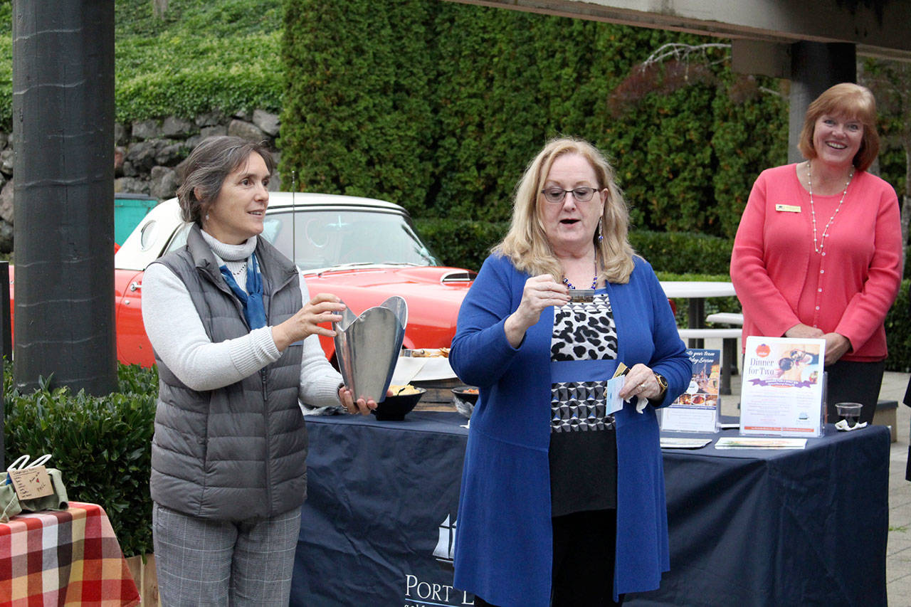 Cammy Brown of Peninsula Legal Secretarial Services draws a name as part of a raffle held at the business expo. The prizes she was awarding were gift cards to a local coffee shop. (Zach Jablonski/Peninsula Daily News)