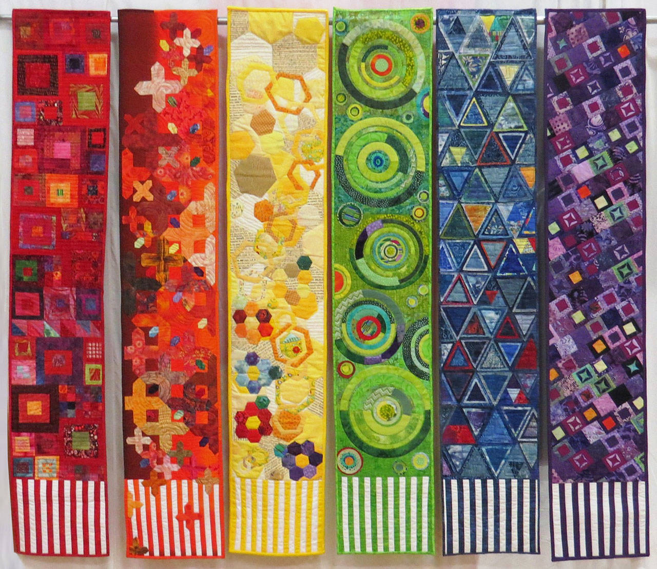 “Geometry In Textiles” by Betty Cook (red), Nancy Wilcox (orange), Mary Ann Clayton (yellow), Peggy St. George (green), Janet Green (blue) and Anne Davies (purple). Submitted art