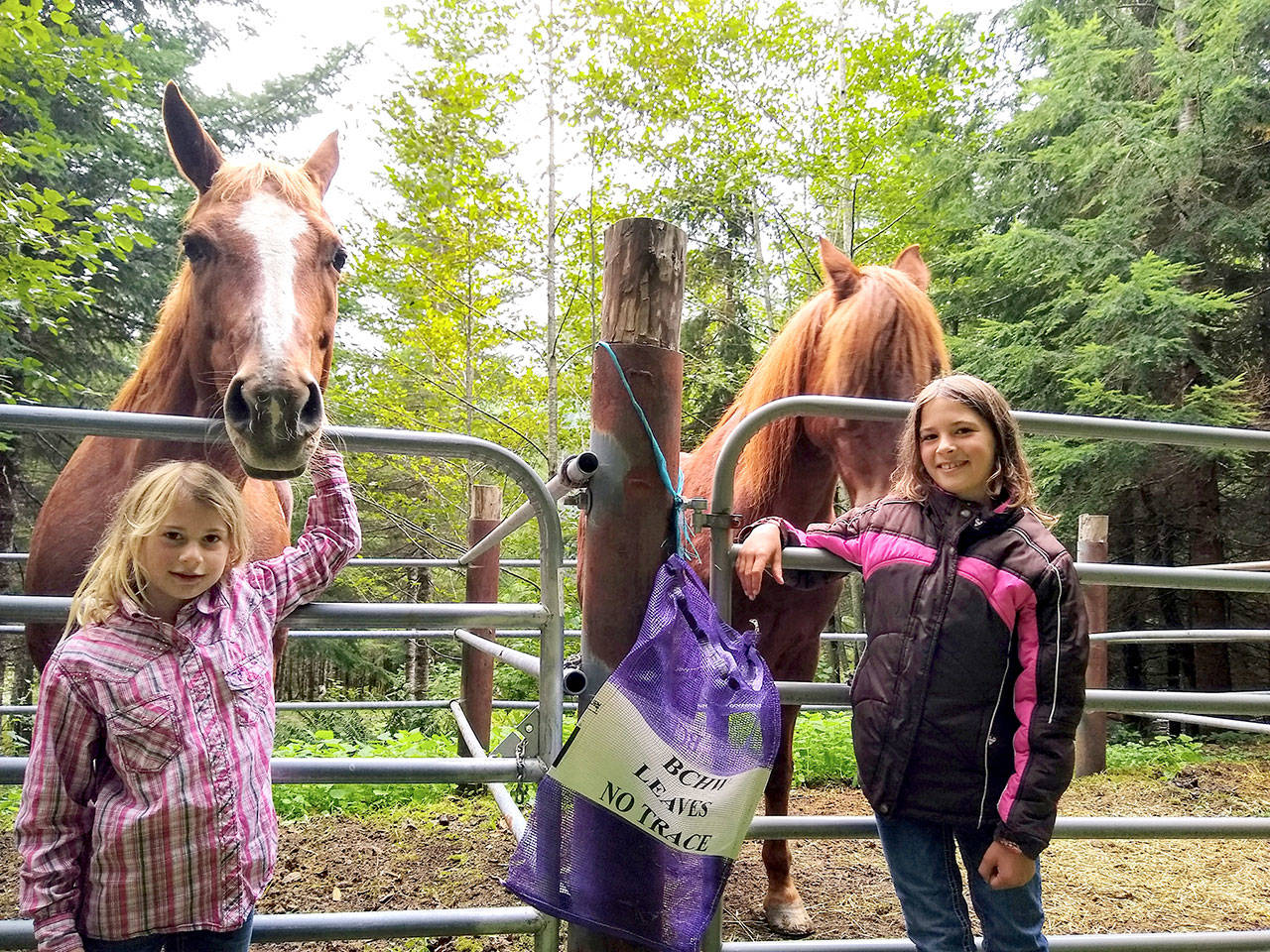 Sloan Pare, 6, hangs out with her horse, Smoking Gun, along with her sister Reegan Pare, 9, and her bashful ride, Tango. (Zorina Barker/for Peninsula Daily News)