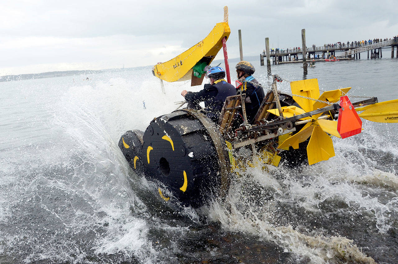 Team Minions in Black from Gig Harbor plunge full speed into the water course part of the 2017 Kinetic Sculpture Race in Port Townsend. (Peninsula Daily News file photo)