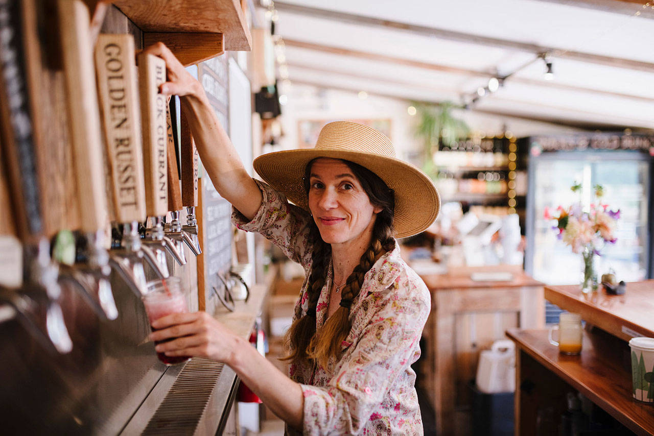 Crystie Kisler, owner of Finnriver Cidery, pulls a draft of cider from a tap. (Jen Lee Light)
