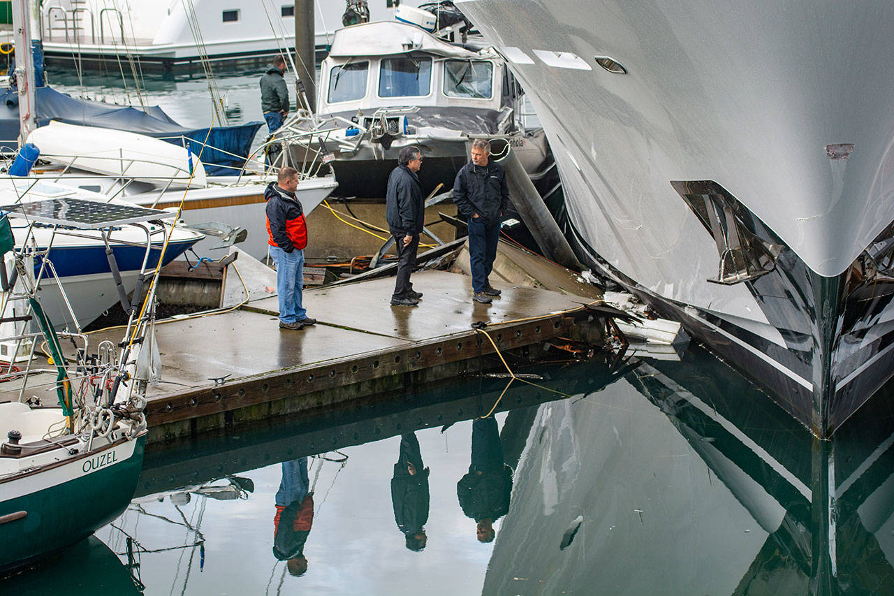 Officials from Westport look over damage after a Westport yacht smashed into docks at the Port Angeles Boat Haven on Monday morning. (Jesse Major/Peninsula Daily News)