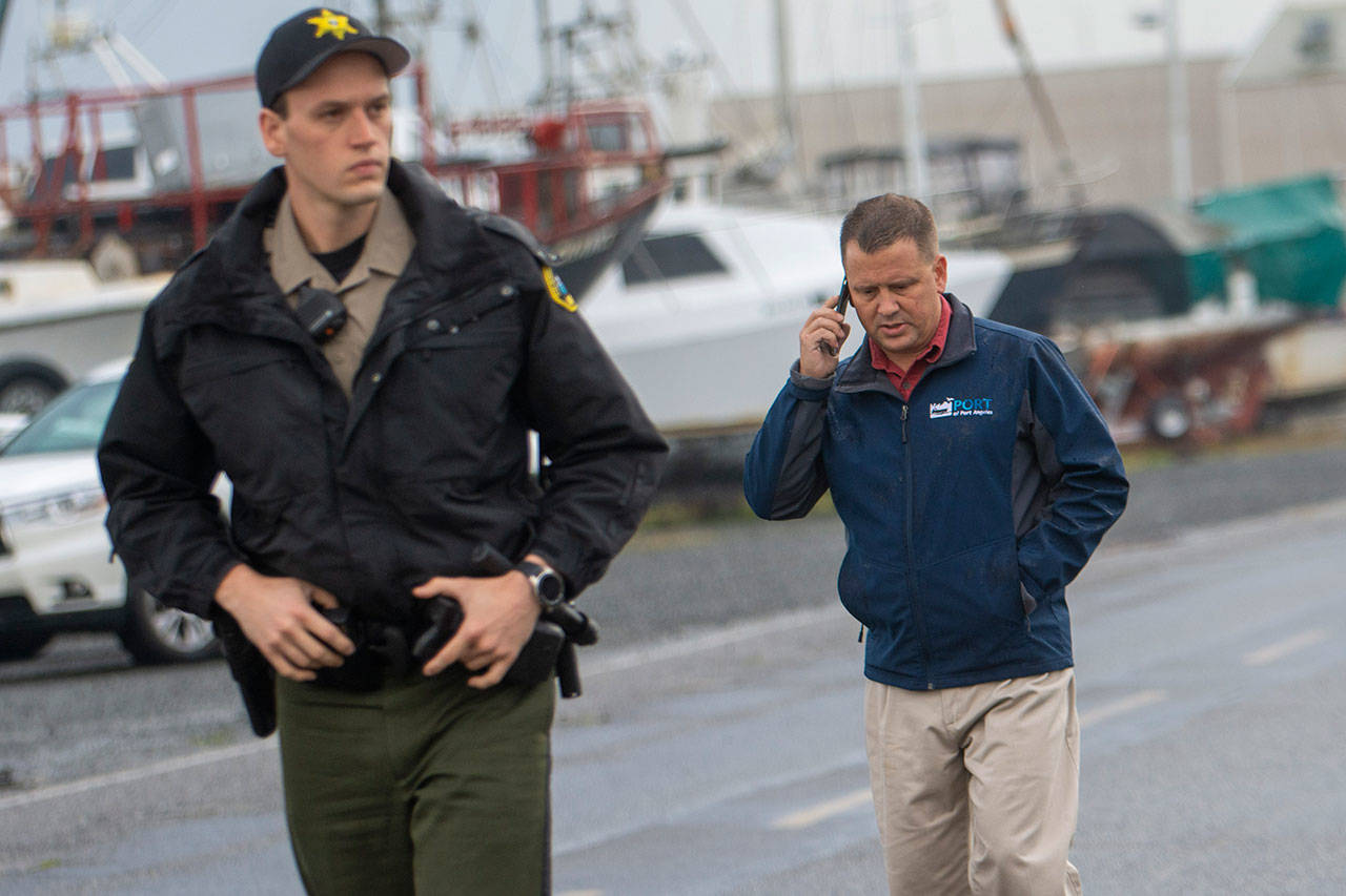 John Nutter, Port of Port Angeles director of property, marinas and airports, takes a call while at the scene where a Westport yacht smashed into docks at the Port Angeles Boat Haven on Monday morning, damaging several boats. (Jesse Major/Peninsula Daily News)