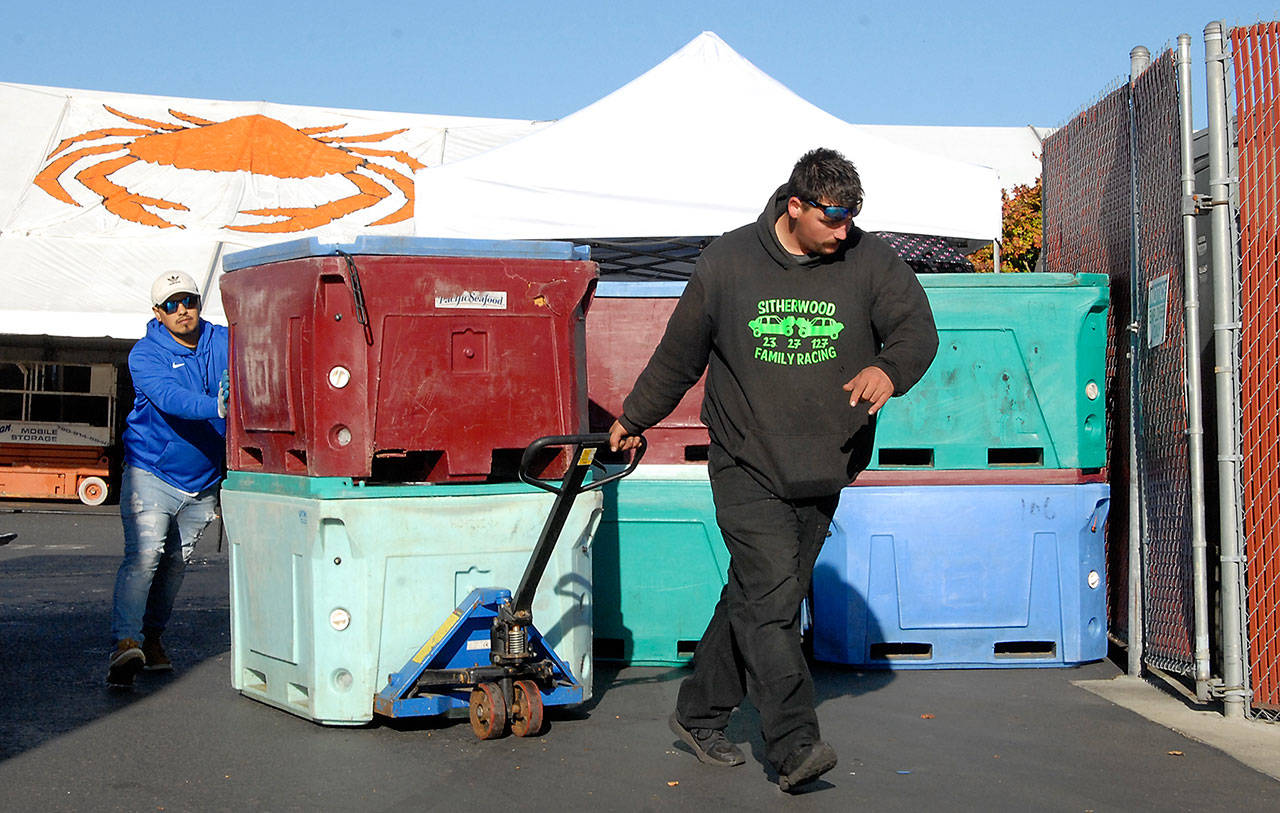 Josh Sitherwood of Olympia, front, and Al Barajas of Forks move freshly delivered cases of crab Thursday in the preparation area of the Dungeness Crab and Seafood Festival in Port Angeles. (Keith Thorpe/Peninsula Daily News)