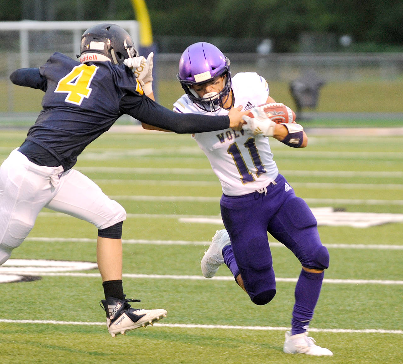 Sequim’s Michael Young, right, fends off the tackle attempt of Forks’ Carter Windle during a game earlier this season. (Michael Dashiell/Olympic Peninsula News Group)