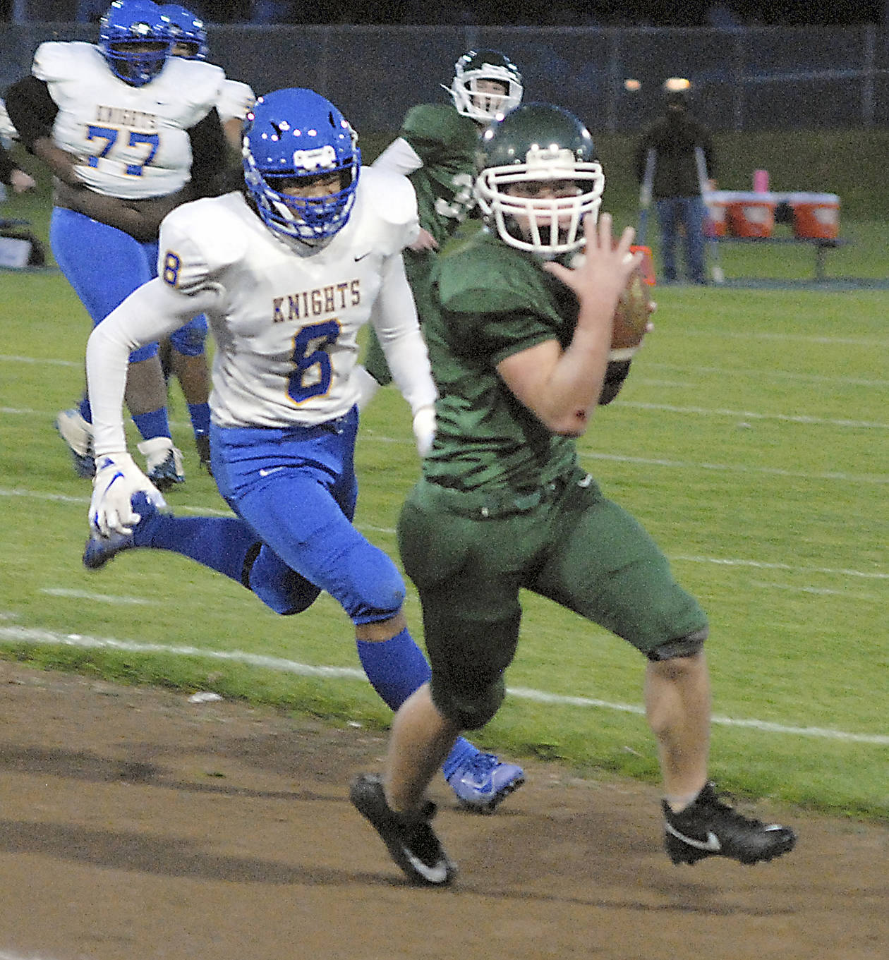 Keith Thorpe/Peninsula Daily News Port Angeles wide receiver Nolan Hughes brings down a pass and is immediately pursued by Bremerton’s Kaipo Retome on Friday night at Port Angeles Civic Field.