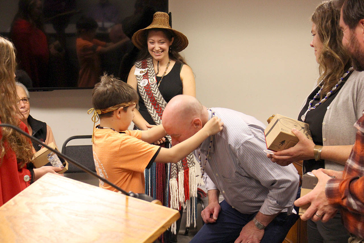 Joshua Freeman of the Jamestown S’Kallam Tribe places a necklace on Commissioner David Sullivan at the Jefferson County Board of County Commissioners meeting Monday morning, where the commissioners proclaimed the day to be “Indigenous Peoples Day.” (Zach Jablonski/Peninsula Daily News)