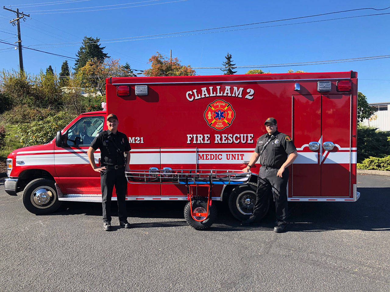Firefighter/EMT Zach Gear, left, and firefighter/paramedic Ian Brueckner display the new litter with wheel attachment recently purchased by Clallam 2 Fire Rescue with funding received by the Clallam County Physicians Community Benefit Fund grant. (Clallam County Fire District 2)