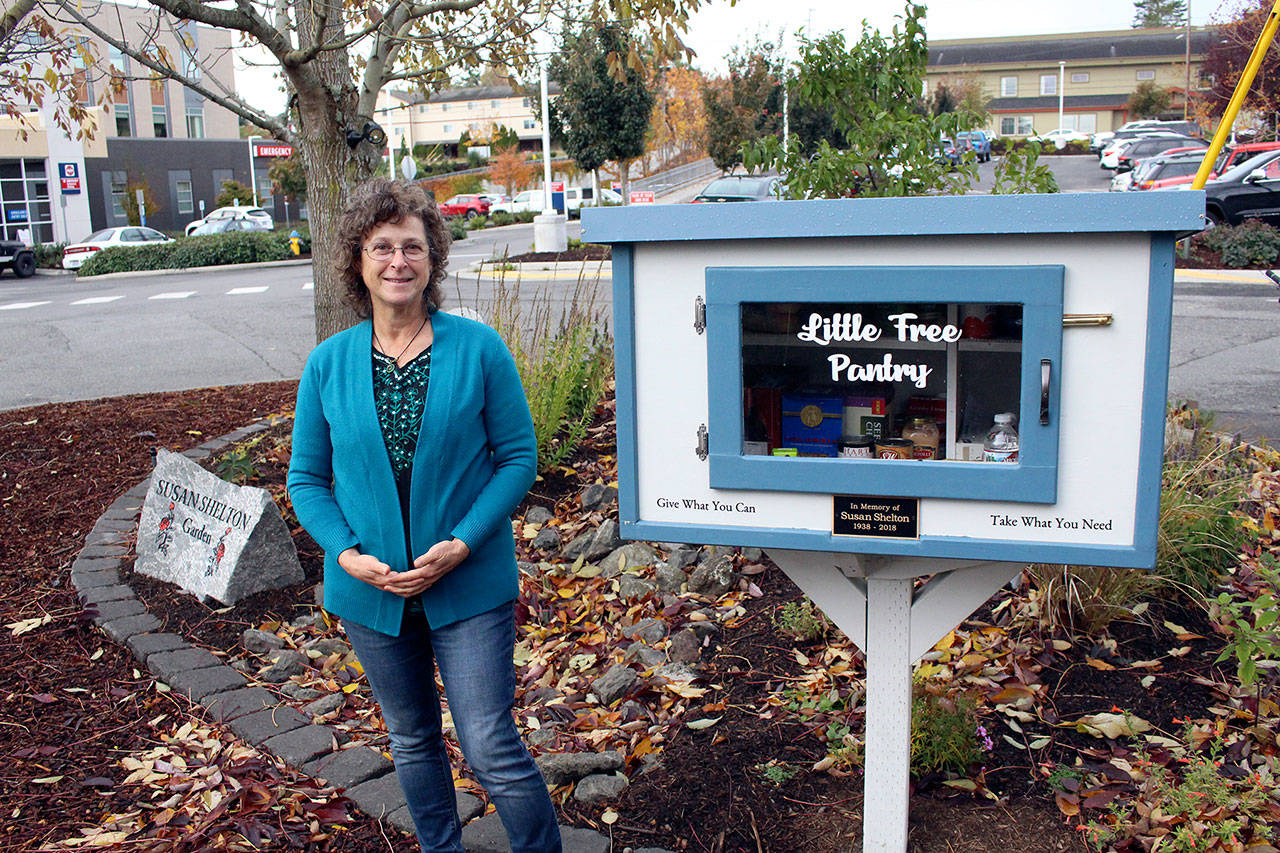 Dove House Development Administration Assistant Bekka Bloom stands with the free Little Pantry located near the north parking lot of Jefferson Healthcare and the front entrance to Dove House on Friday. (Zach Jablonski/Peninsula Daily News)