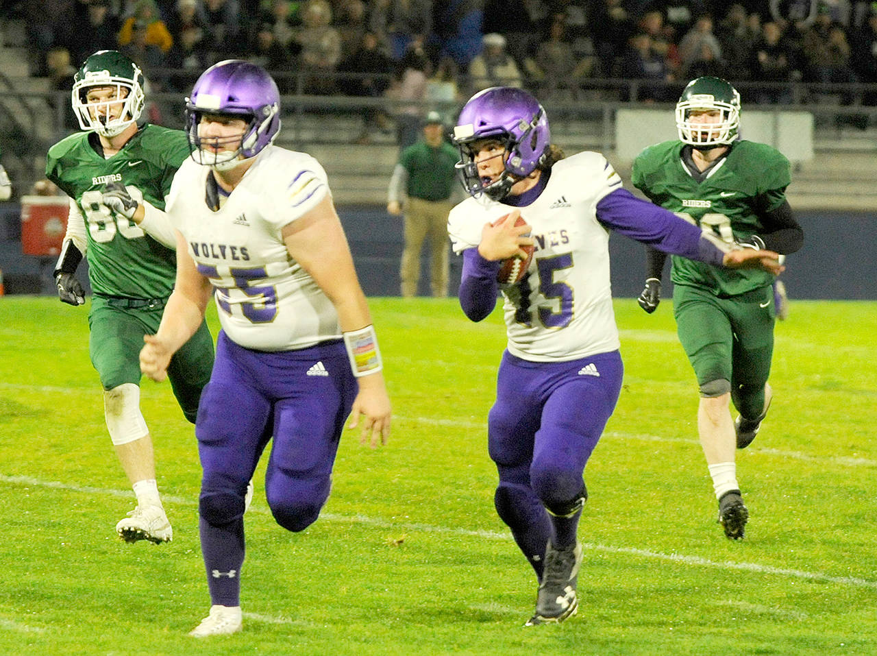 Michael Dashiell/Olympic Peninsula News Group With Brandon Barnett (55) leading the way, Sequim quarterback Taig Wiker picks up a big gain in the first quarter of the Rainshadow Rumble at Civic Field on Friday night.