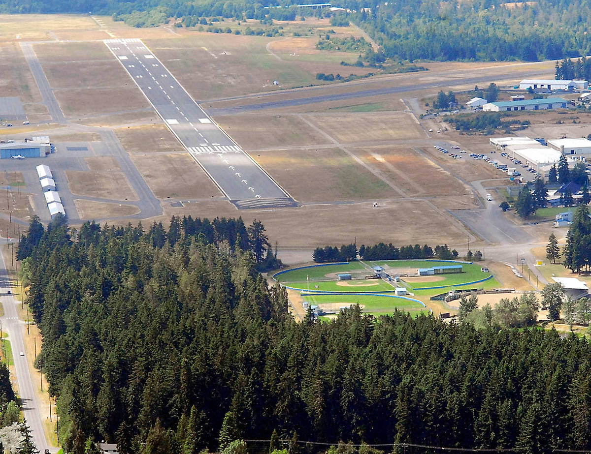 The 6,347-foot long main runway at William R. Fairchild International Airport in Port Angeles, known officially as 8/26, is shown in this July 2011 file photo. The heavily-forested Lincoln Park with its athletic fields is shown at bottom. (Keith Thorpe/Peninsula Daily News)