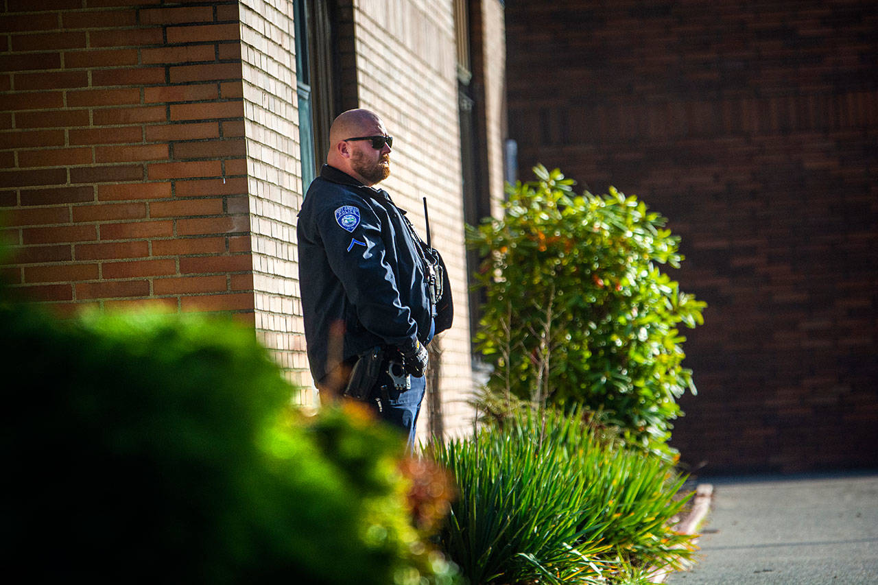 Port Angeles Police Officer Mike Johnson stands guard outside Stevens Middle School on Monday morning. Police took a male student into custody after threats were posted on Snapchat. (Jesse Major/Peninsula Daily News)