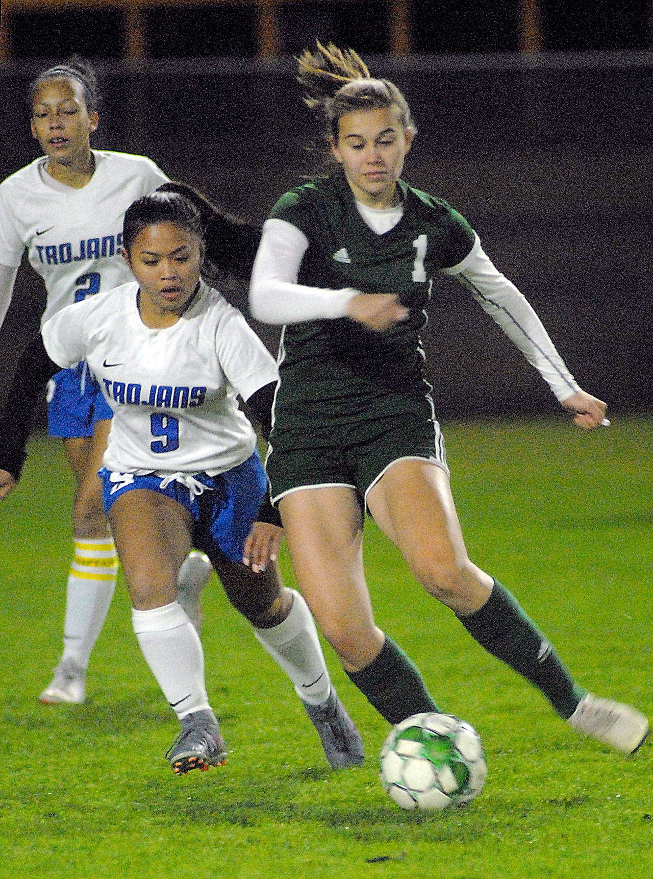 Keith Thorpe/Peninsula Daily News Port Angeles’ Bailee Larson, right, slips past the defense of Olympic’s Althea White as White’s teammate, Jasmine Gist, looks on during Tuesday night’s match at Port Angeles Civic Field.