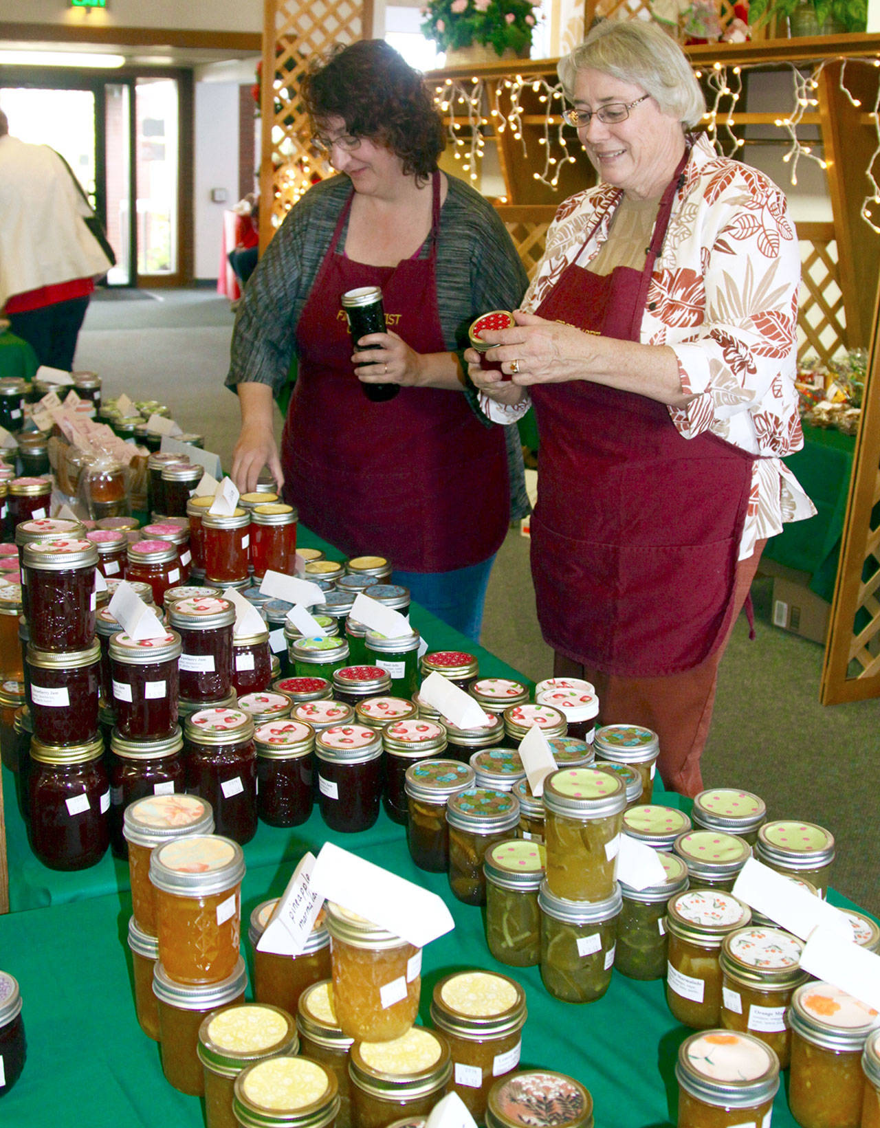 Kim Luker, left, and Robin Sweeney look over the many homemade jams and jellies for sale at the 2018 Holiday Bazaar sale at the First Baptist Church in Port Angeles this file photo. The church’s annual bazaar is among several scheduled this weekend on the North Olympic Peninsula. (Dave Logan/for Peninsula Daily News)