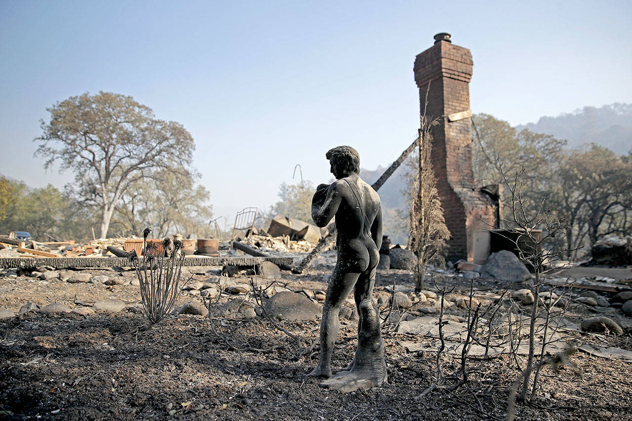 A charred statue stands among ashes in front of a home destroyed in the Kincade Fire near Healdsburg, Calif., on Thursday. (Charlie Riedel/The Associated Press)