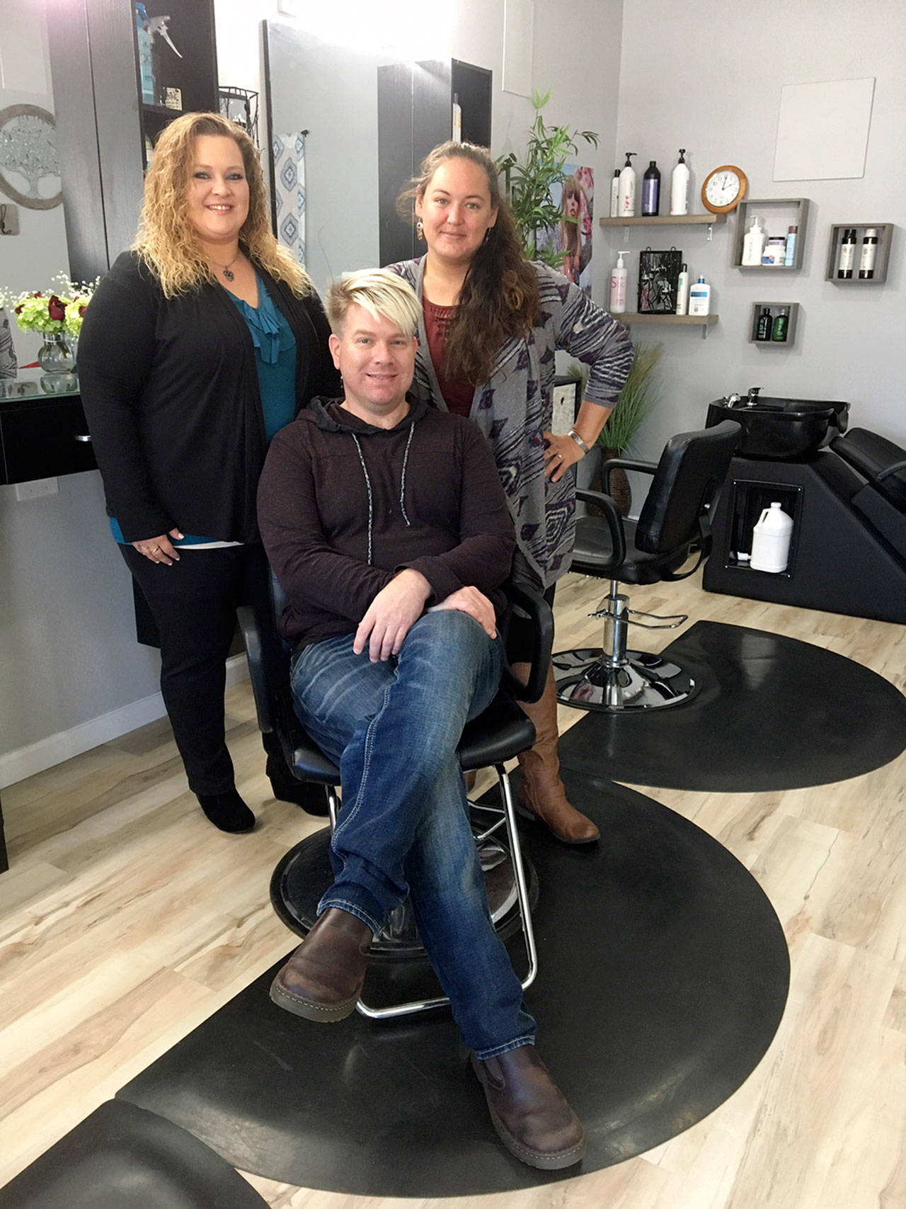 Members of the team at Amazing Chanes Hair Studio are, standing on left, cosmetologist and braider Tina Tangedahl; on right, nail technician Jennifer Hedin; and, seated, studio owner Kyle Ellis. (Vivian Elvis Hansen/Peninsula Daily News)