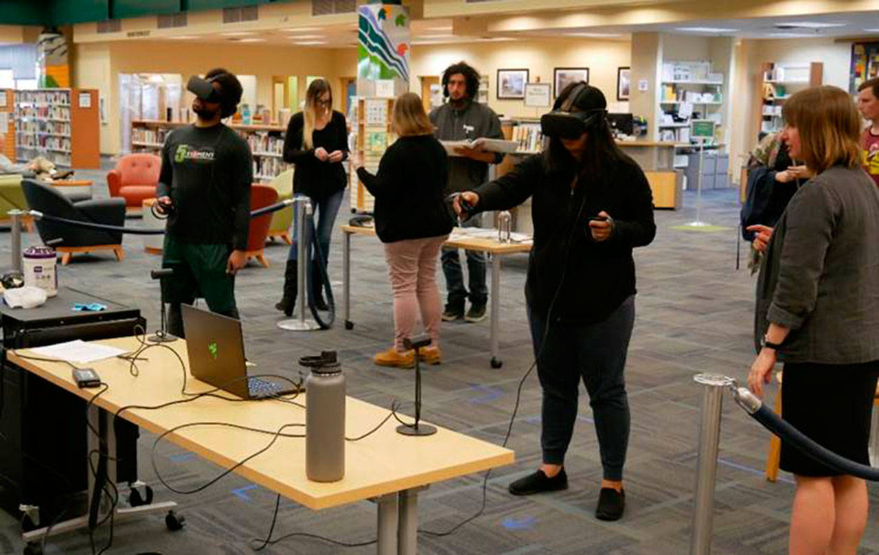 Patrons try virtual reality machines at the Port Angeles Library. Virtual reality technology sessions are set for November and December at Sequim and Port Angeles library branches. Photo courtesy of North Olympic Library System