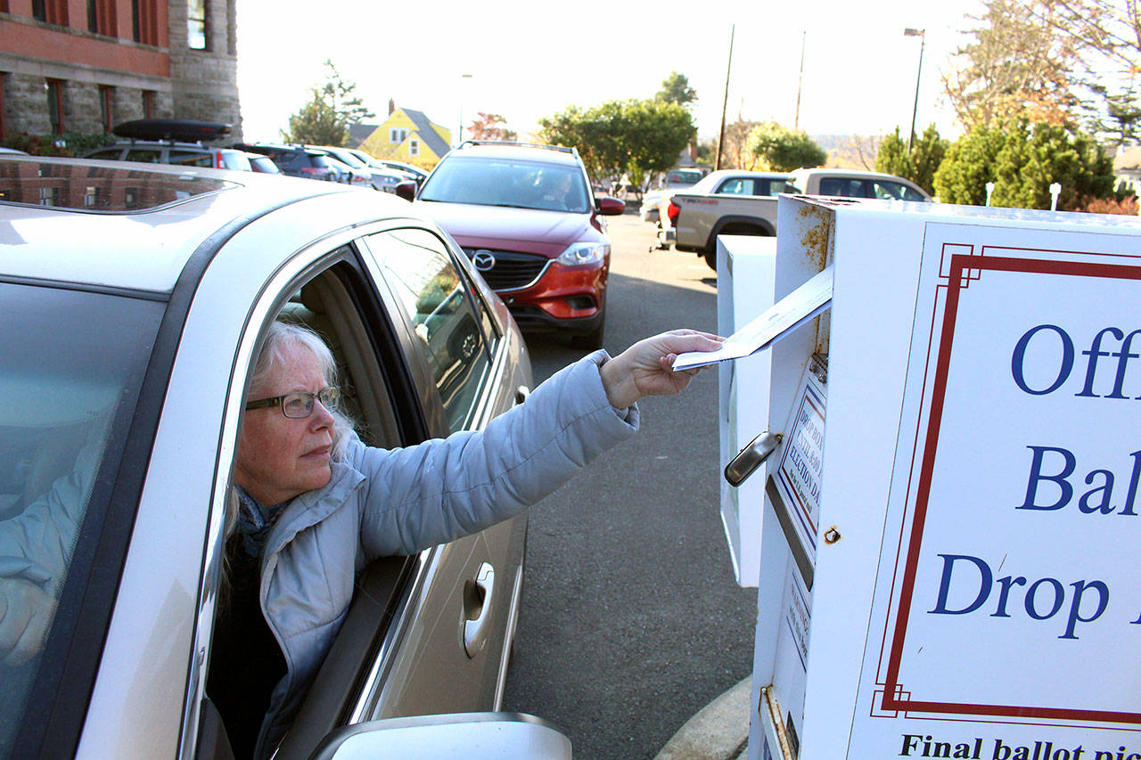 Lindsay Hamilton places her ballot in the ballot dropbox behind the Jefferson County Courthouse on Tuesday afternoon. (Zach Jablonski /Peninsula Daily News)