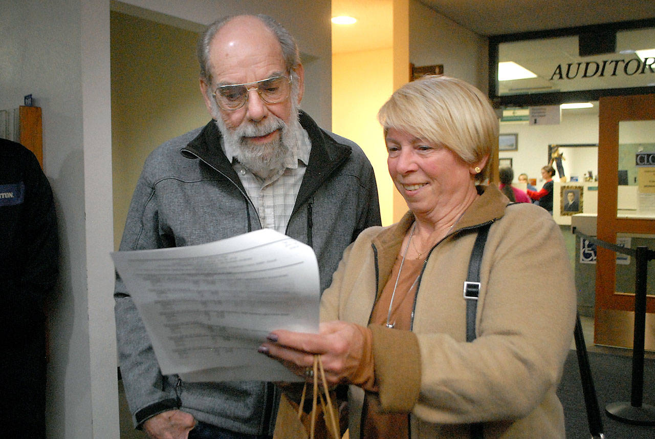 Incumbent Port of Port Angeles Commissioner Connie Beauvais, right, looks over election results with her husband, Jim Beauvais, on election night at the Clallam County Courthouse in Port Angeles. (Keith Thorpe/Peninsula Daily News)