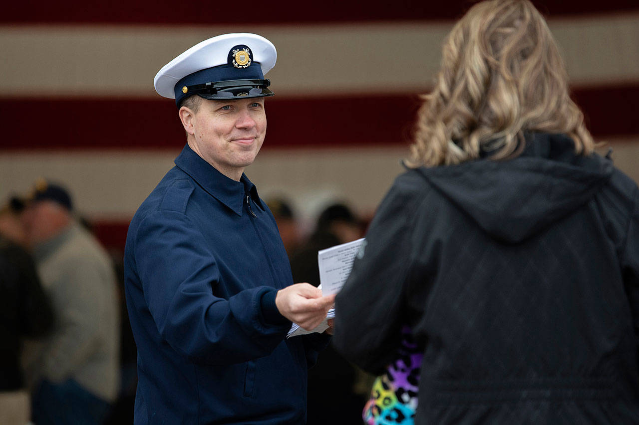 Petty Officer First Class Sam Allen welcomes people to the Veterans Day ceremony at U.S. Coast Guard Air Station/Sector Field Office Port Angeles on Monday. (Jesse Major/Peninsula Daily News)