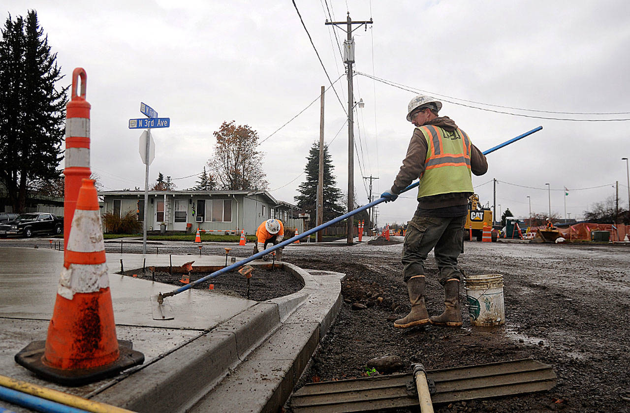 <strong>Michael Dashiell</strong>/Olympic Peninsula News Group                                Tim Coville, foreground, and Peter Gish work on sidewalks along West Fir Street on Tuesday. The city’s biggest current project at $3.4 million, the project’s completion is tentatively slated for late spring, city staff said.