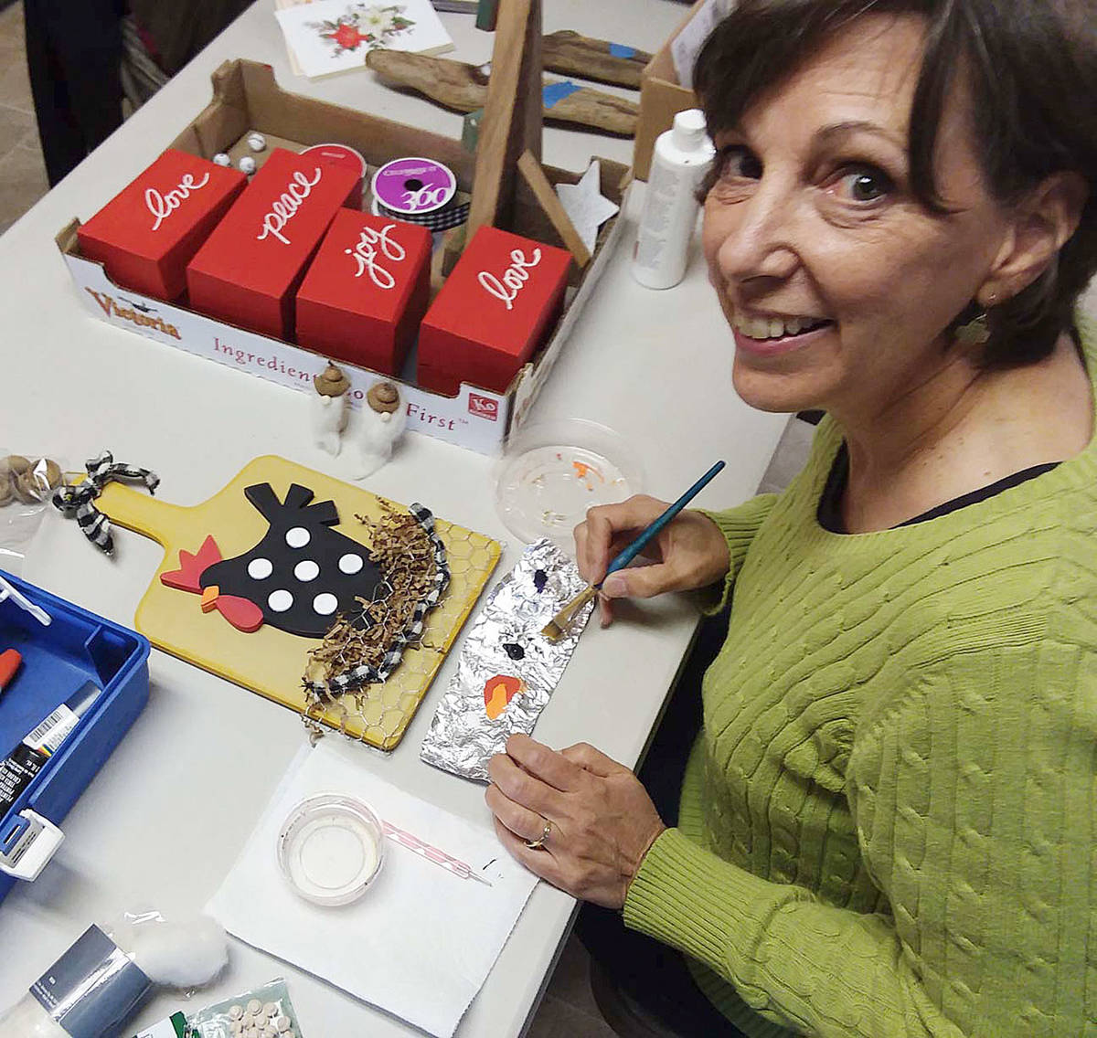 Former Sequim artist Karin Anderson, now a Santa Fe resident, helps contributors to the Dungeness Valley Luther Church Yuletide Bazaar at a recent “work session” to craft items for the annual event.