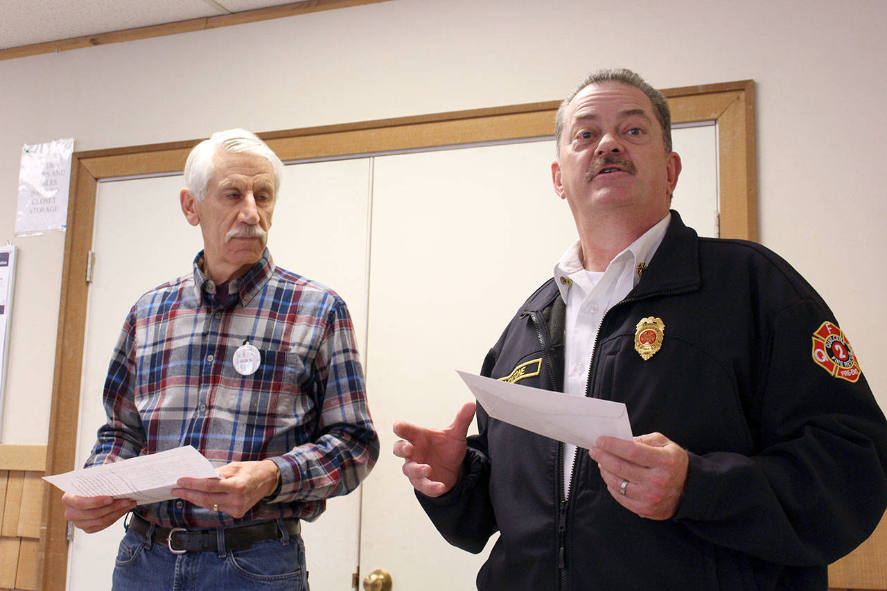 Quilcene Fire Chief Frank Montone, right, expresses his thanks to the Quilcene-Brinnon Garden Club for a $200 grant for Quilcene Fire Rescue to help fund the team’s conversion to battery operated extraction tools Thursday afternoon at the Quilcene Community Center. (Zach Jablonski/Peninsula Daily News)