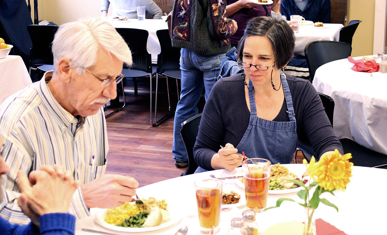 St. Paul’s Episcopal Church’s Thanksgiving meal organizer Elizabeth Bindschadler takes a break to eat with her husband, Bob, during the church’s Wednesday community Thanksgiving meal, where Elizabeth was helping keep more than 20 volunteers organized and the meal running smoothly. (Zach Jablonski/Peninsula Daily News)