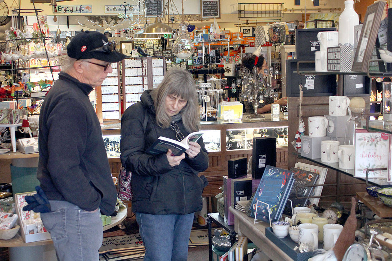 Ron, left, and Linda Jewchyn check out a book for sale at the Green Eyeshade in Port Townsend on Small Business Saturday. The couple from Montesano, Wa, was spending the weekend with family at Fort Worden. (Zach Jablonski/Peninsula Daily News)