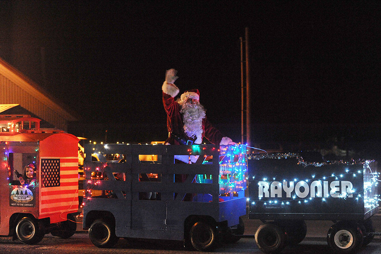 Santa rides on the West End Business & Professional Association’s train during the Twinkle Light Parade down Forks Avenue, en route to the Christmas tree lighting on Saturday evening. (Lonnie Archibald/for Peninsula Daily News)