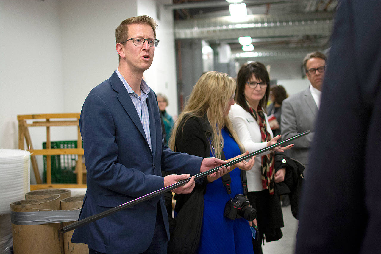 U.S. Rep. Derek Kilmer examines a carbon fiber pole, a light-weight component in pickleball nets, during a tour of the Composite Recycling Technology Center in Port Angeles. (Jesse Major/Peninsula Daily News)