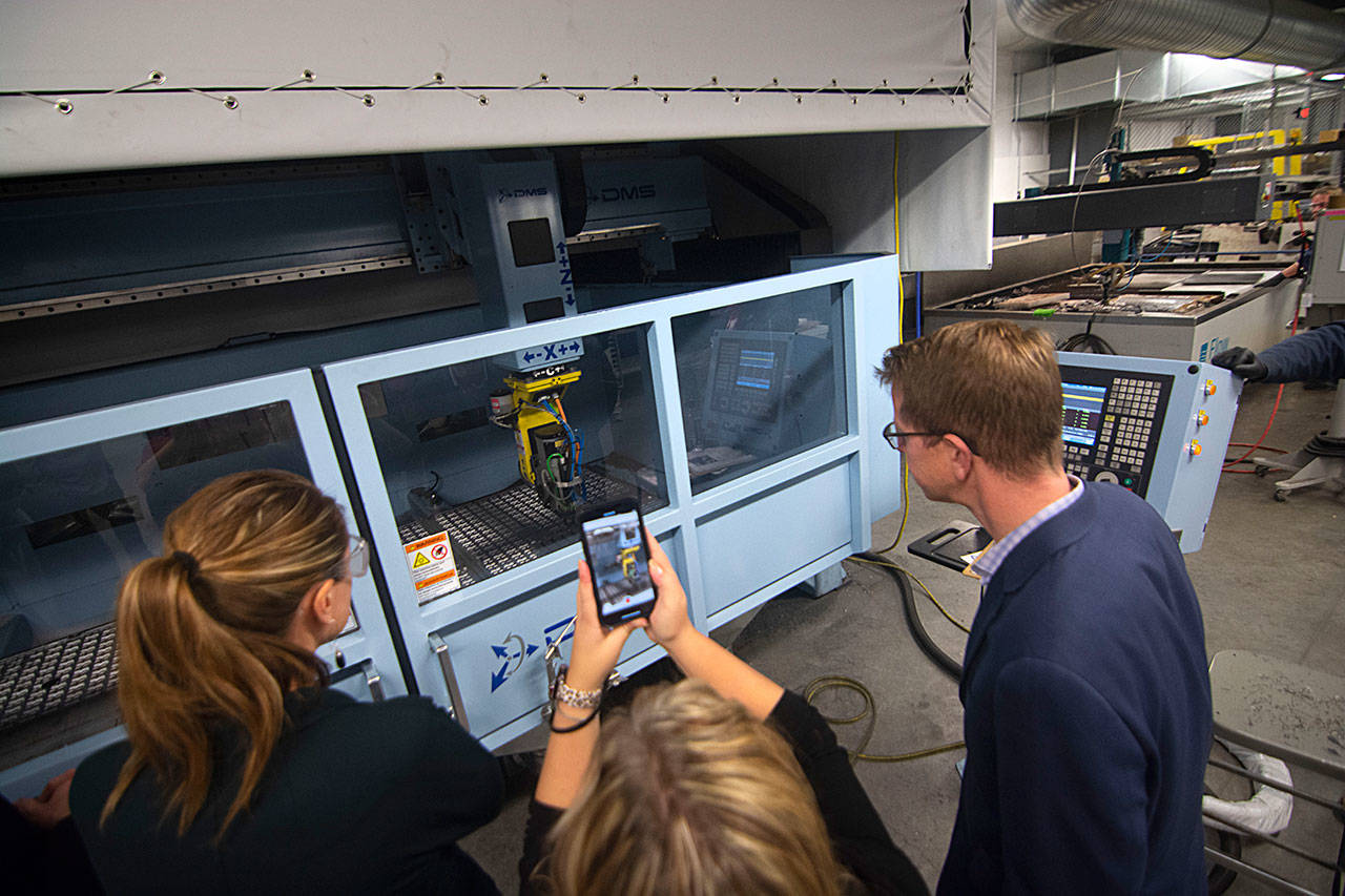 U.S. Rep. Derek Kilmer and others look over a 3D printer at the Composite Recycling Technology Center. (Jesse Major/Peninsula Daily News)