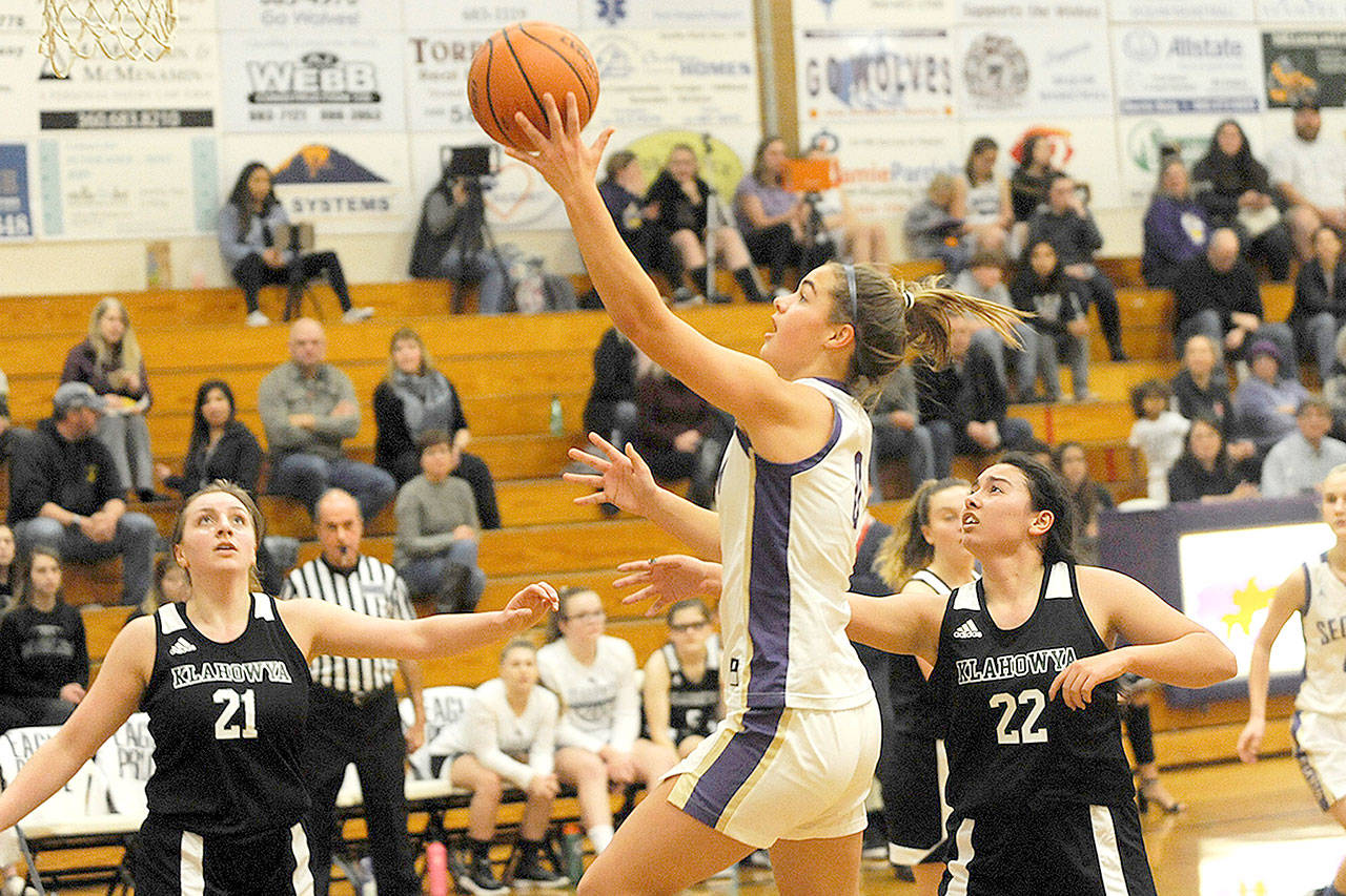 Sequim Wolves forward Hope Glasser, center, goes up for a layup against the Klahowya Eagles during the Wolves’ 73-17 win over the Eagles on Dec. 2. Glasser scored 11 points in the win. (Conor Dowley/Olympic Peninsula News Group)