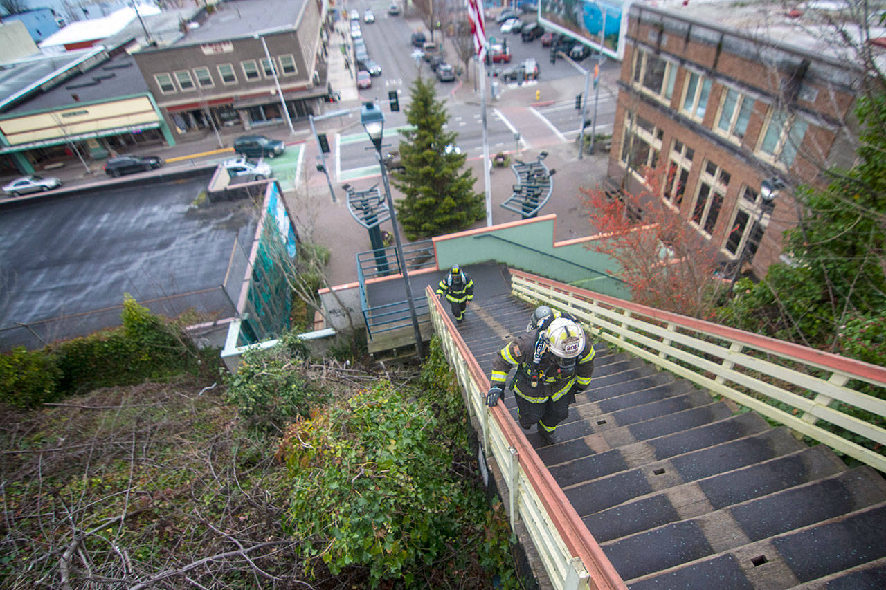 Clallam Fire District No. 2 Chief Jake Patterson, front, climbs stairs Sunday in downtown Port Angeles. Firefighters across the North Olympic Peninsula are preparing Leukemia and Lymphoma Society Firefighter Stairclimb scheduled for March 8, 2020. (Jesse Major/Peninsula Daily News)