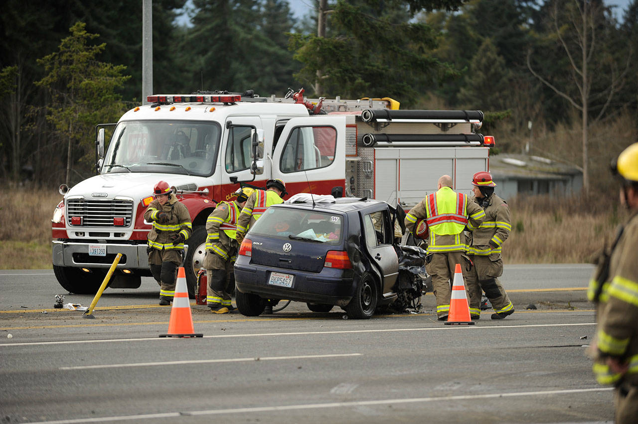 Firefighters with Clallam County Fire District 3 assess damages of a two-vehicle collision on U.S. Highway 101 near Gilbert Road on Tuesday. Three people involved were sent to area hospitals. (Michael Dashiell/Olympic Peninsula News Group)