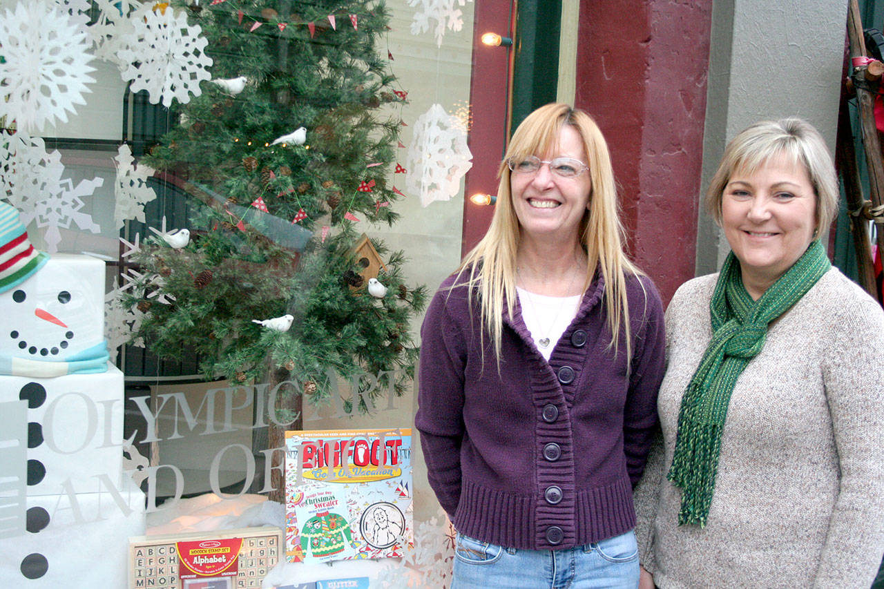 Mickey Griffith, left, and store owner Heidi Hoglund of Olympic Art and Office were presented the first-place Gold Award in the Port Townsend Main Street Program’s annual holiday window display contest. (Brian McLean/Peninsula Daily News)