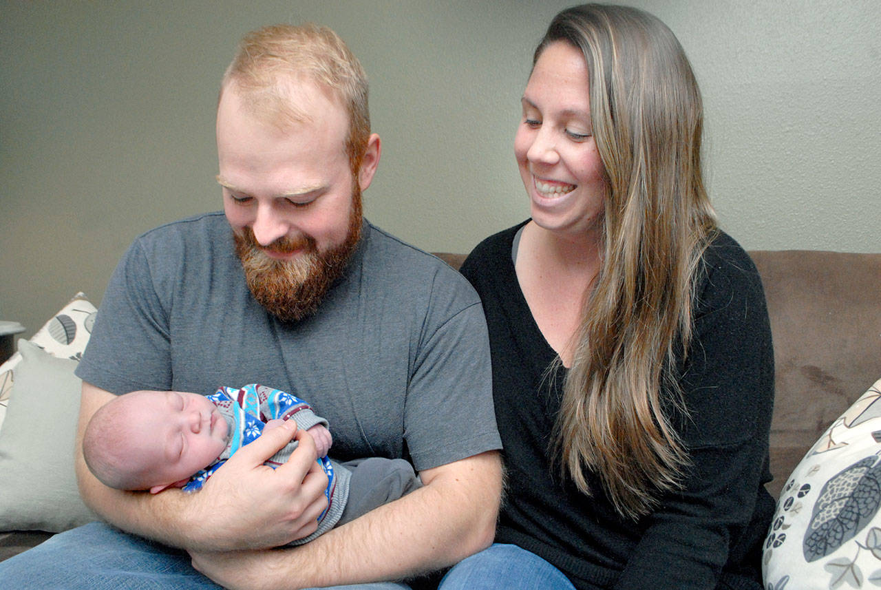 Cortland and Libby Waldron of Port Angeles admire their infant child, Henry James Waldron, who was born Dec. 2 in the back seat of the couple’s Suburban along state Highway 20 in Jefferson County. (Keith Thorpe/Peninsula Daily News)