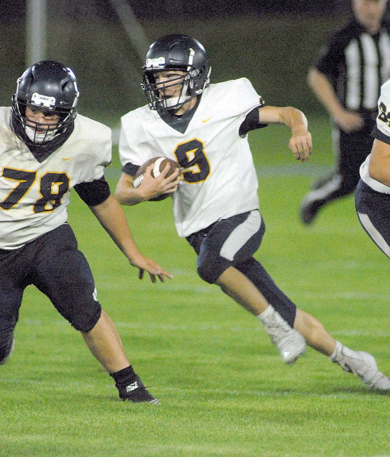 Forks’ Dalton Kilmer looks for a block from teammate Tyler Ellis during a game against Port Angeles in September. Currently a Class 1A school, the Spartans will be re-classified as a 2B school beginning next school year. (Keith Thorpe/Peninsula Daily News)