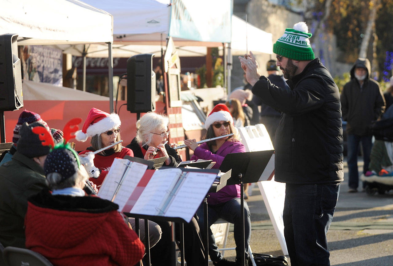 Director Tyler Benedict, right, pictured here leading the Sequim City Band in some festive holiday-themed tunes at the Home Town Holidays in downtown Sequim on Nov. 30, directs the band at the group’s annual “Joyous Sounds” holiday concert set for 3 p.m. Sunday at the Sequim High School auditorium. (Michael Dashiell/Olympic Peninsula News Group)