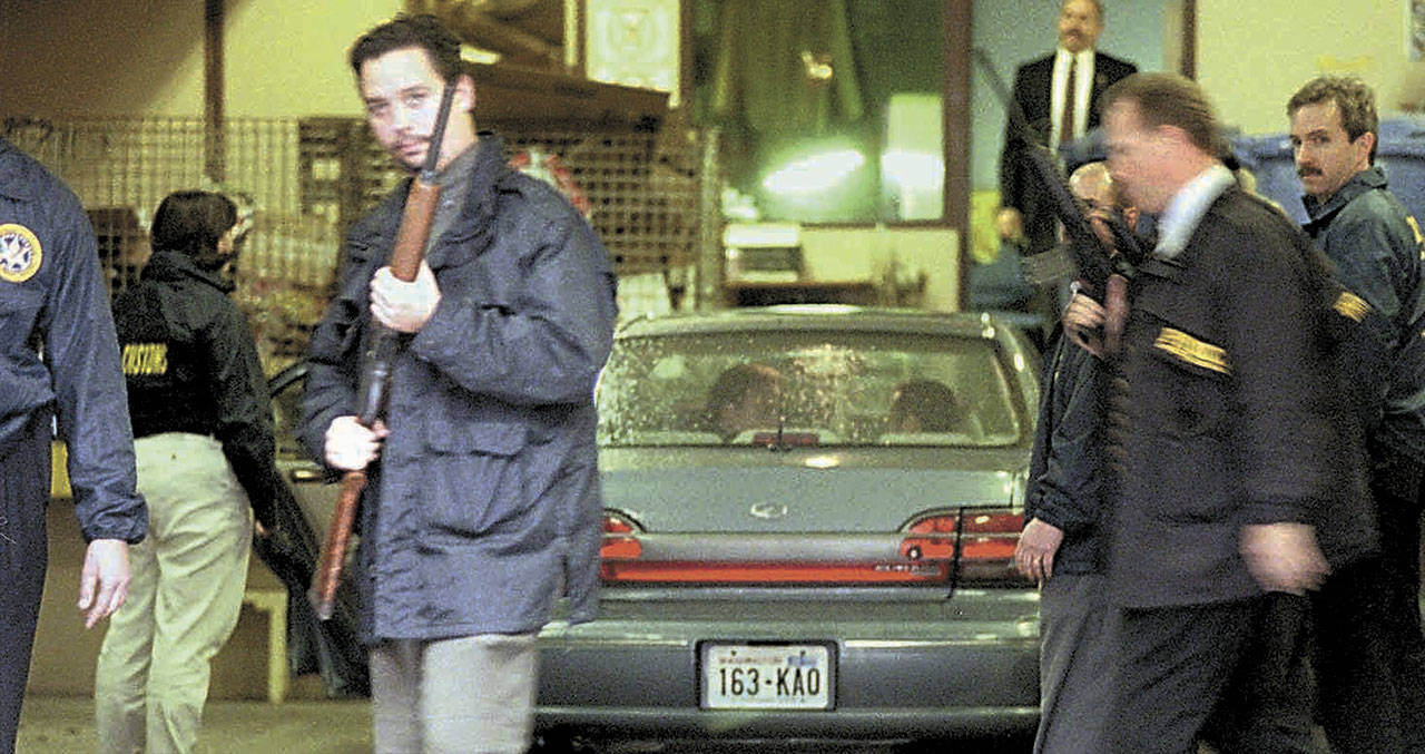U.S. Marshals and Customs agents surround the car carrying suspected Algerian terrorist Ahmed Ressam in the garage of the Federal Courthouse in downtown Seattle on Friday, Dec. 17, 1999. Ressam was arrested Dec. 14, 1999, after taking a ferry to Port Angeles from Victoria with a trunkful of bomb-making materials in his car. Ressam was charged in federal court with bringing nitroglycerin into the United States, in addition to a charge of having false ID and making false statements to U.S. Customs officials. (Alan Berner/The Seattle Times via The Associated Press, file)