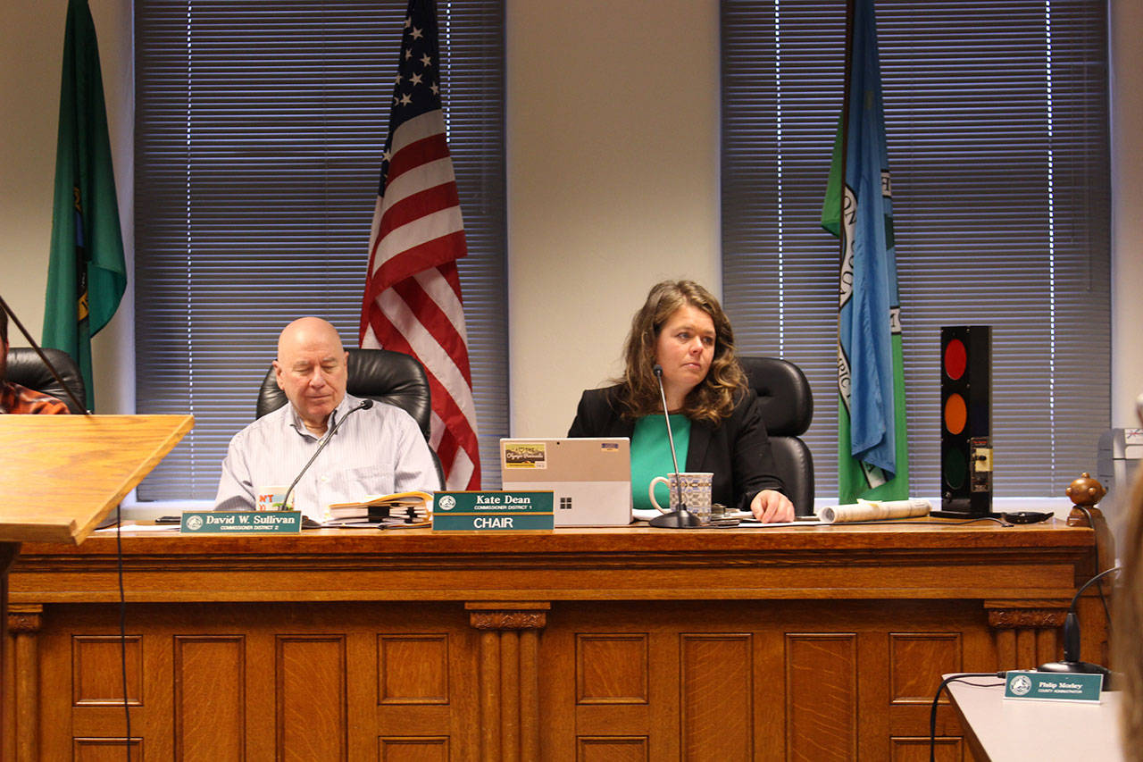 Jefferson County Commissioners David Sullivan, left, and Kate Dean speak about the sales and use tax with county Administrator Philip Morley on Monday at the Jefferson County Courthouse. (Zach Jablonski/Peninsula Daily News)