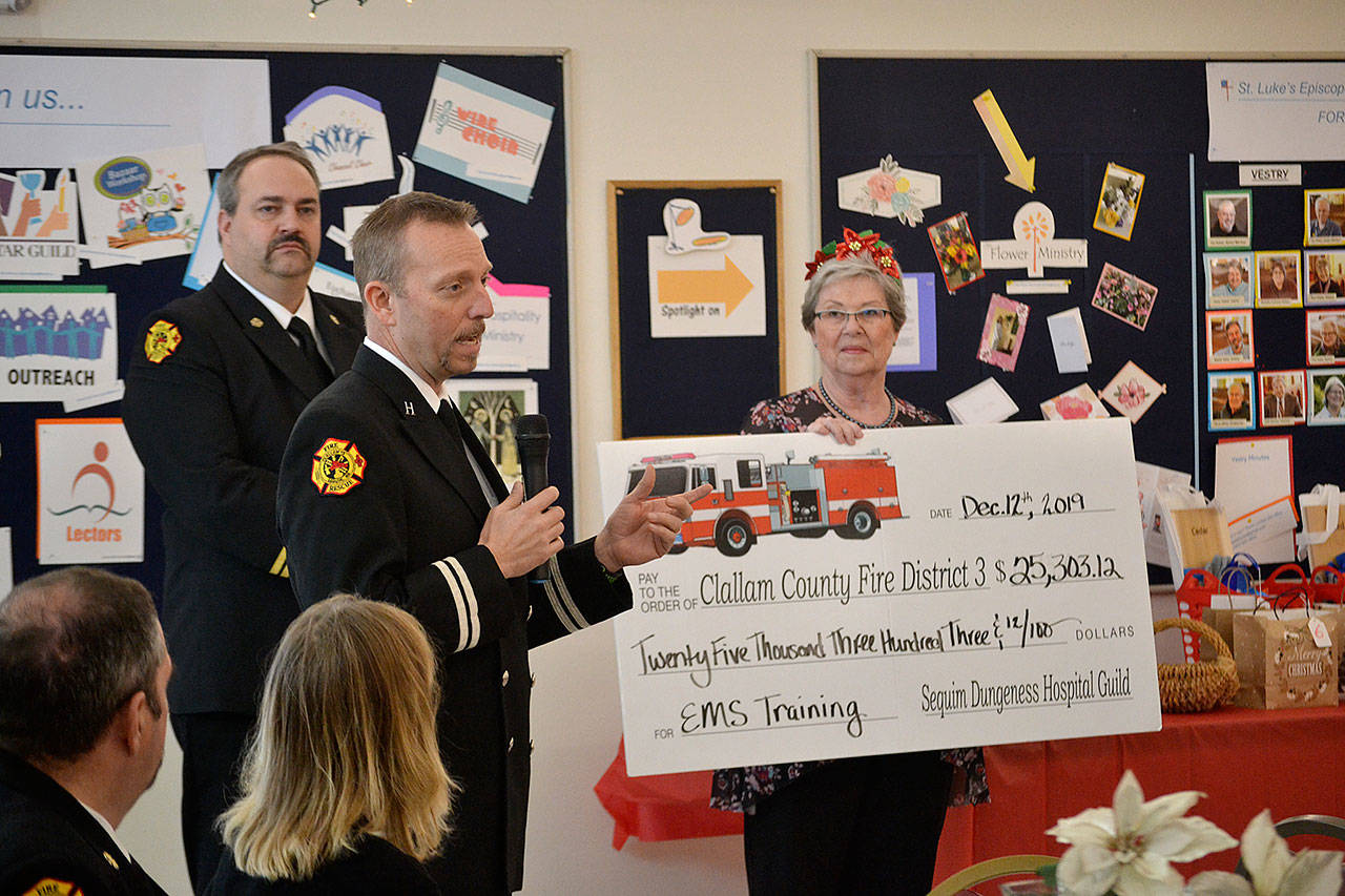 Using a donation from the Sequim-Dungeness Hospital Guild, Capt. Derrell Sharp with Clallam County Fire District 3 told a crowd of guild members Dec. 12 in St. Lukes Episcopal Church that funds will support training for paramedics/EMTs and the public throughout 2020. Guild President Nancy McGovern and other board members presented the check to Sharp and Fire Chief Ben Andrews and other fire district leaders. (Matthew Nash/Olympic Peninsula News Group)
