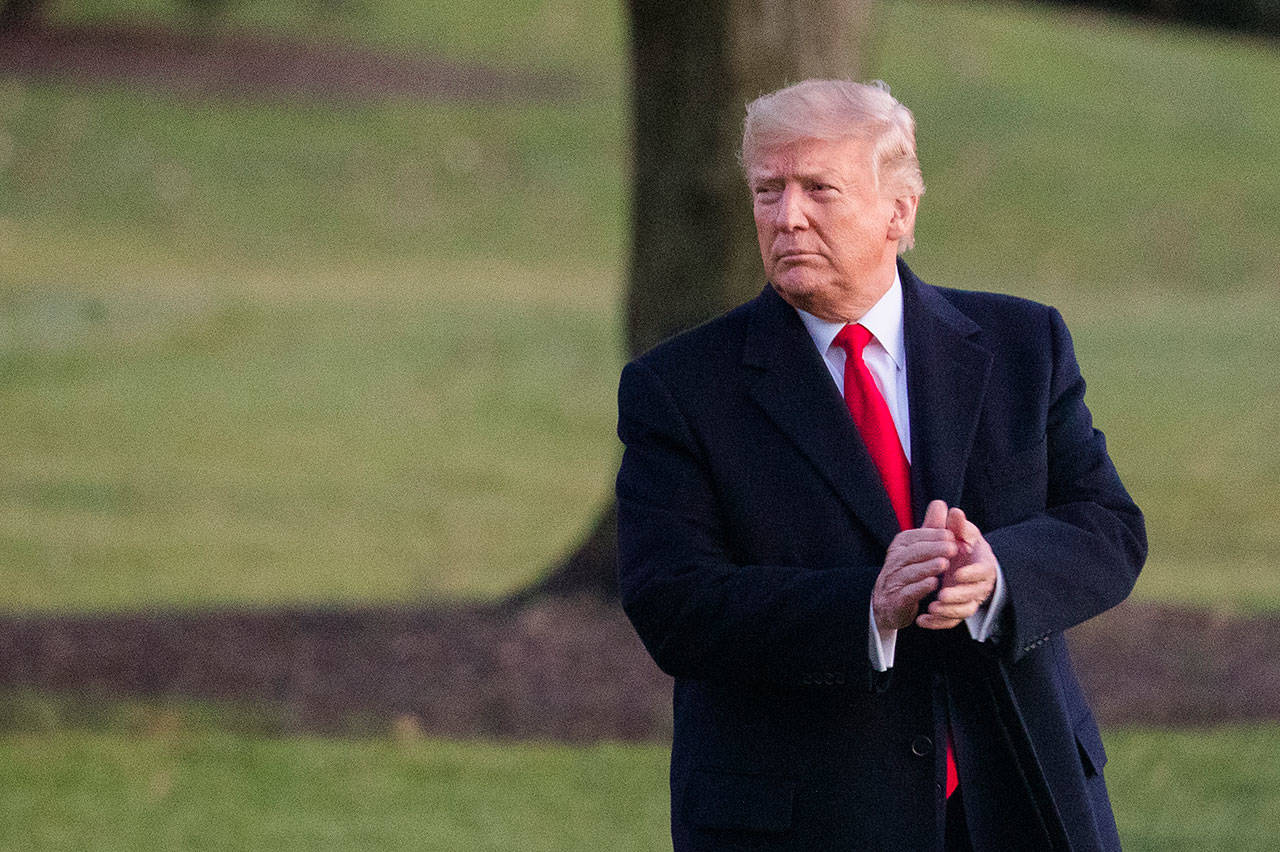 President Donald Trump glances at cheering White House visitors and claps his hands as as he leaves the White House for a campaign trip to Battle Creek, Mich. on Wednesday in Washington. (Manuel Balce Ceneta/The Associated Press)