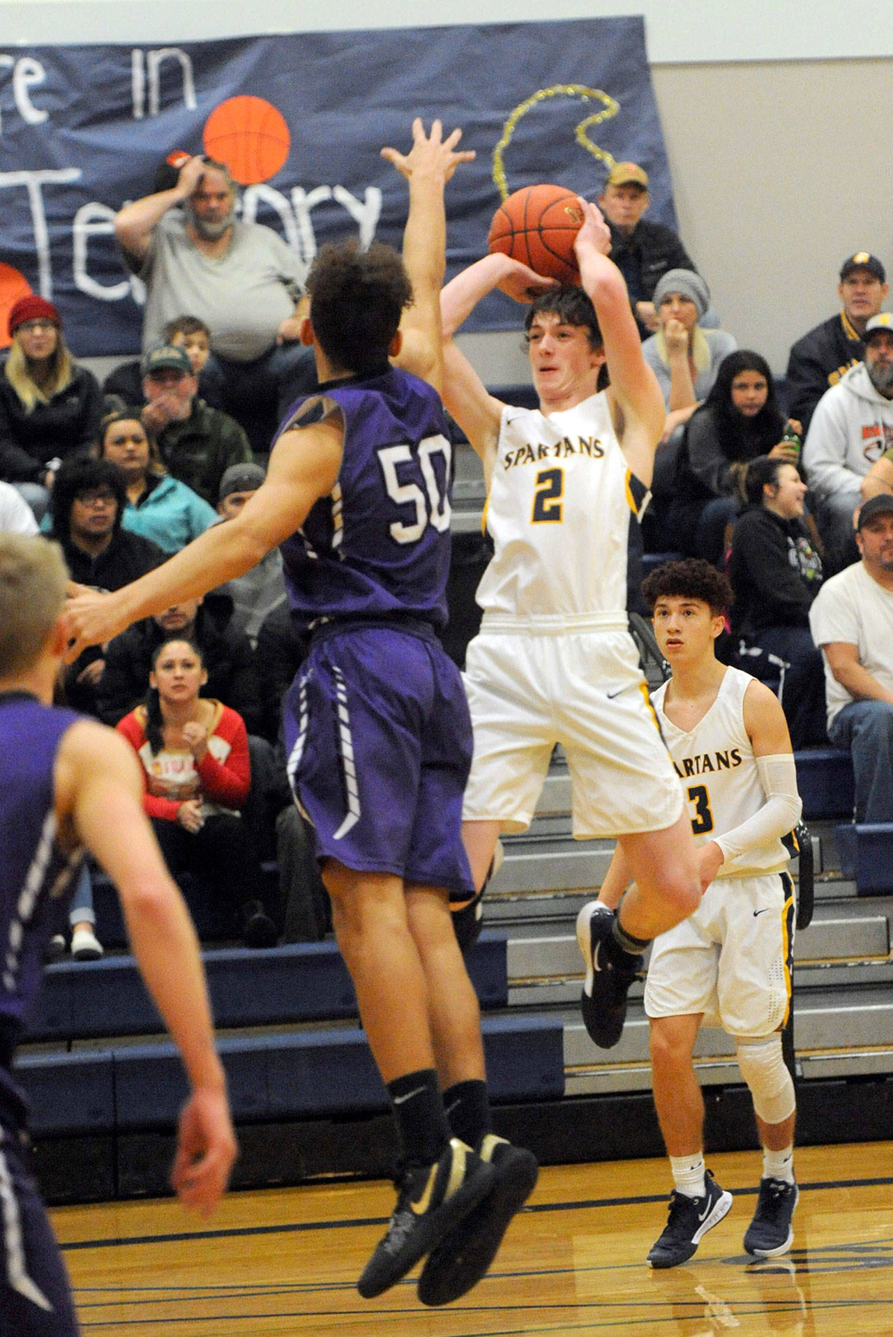 Forks’ Raymond Davis shoots over Sequim’s Hayden Eaton during the Wolves’ 63-49 win over the Spartans on Wednesday. Lonnie Archibald/for Peninsula Daily News
